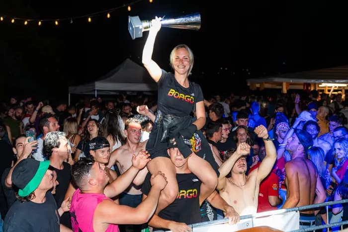 Una ragazza alza il trofeo in mezzo alla folla del Dragon Party
