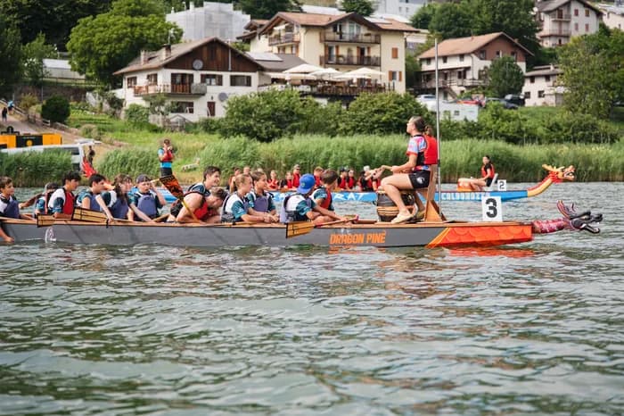 Un dragon boat in gara sotto le case del paese, lungo la riva del lago