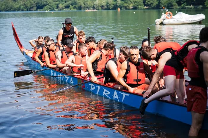Un dragon boat sul lago di Levico, chiuso dalle montagne verdi