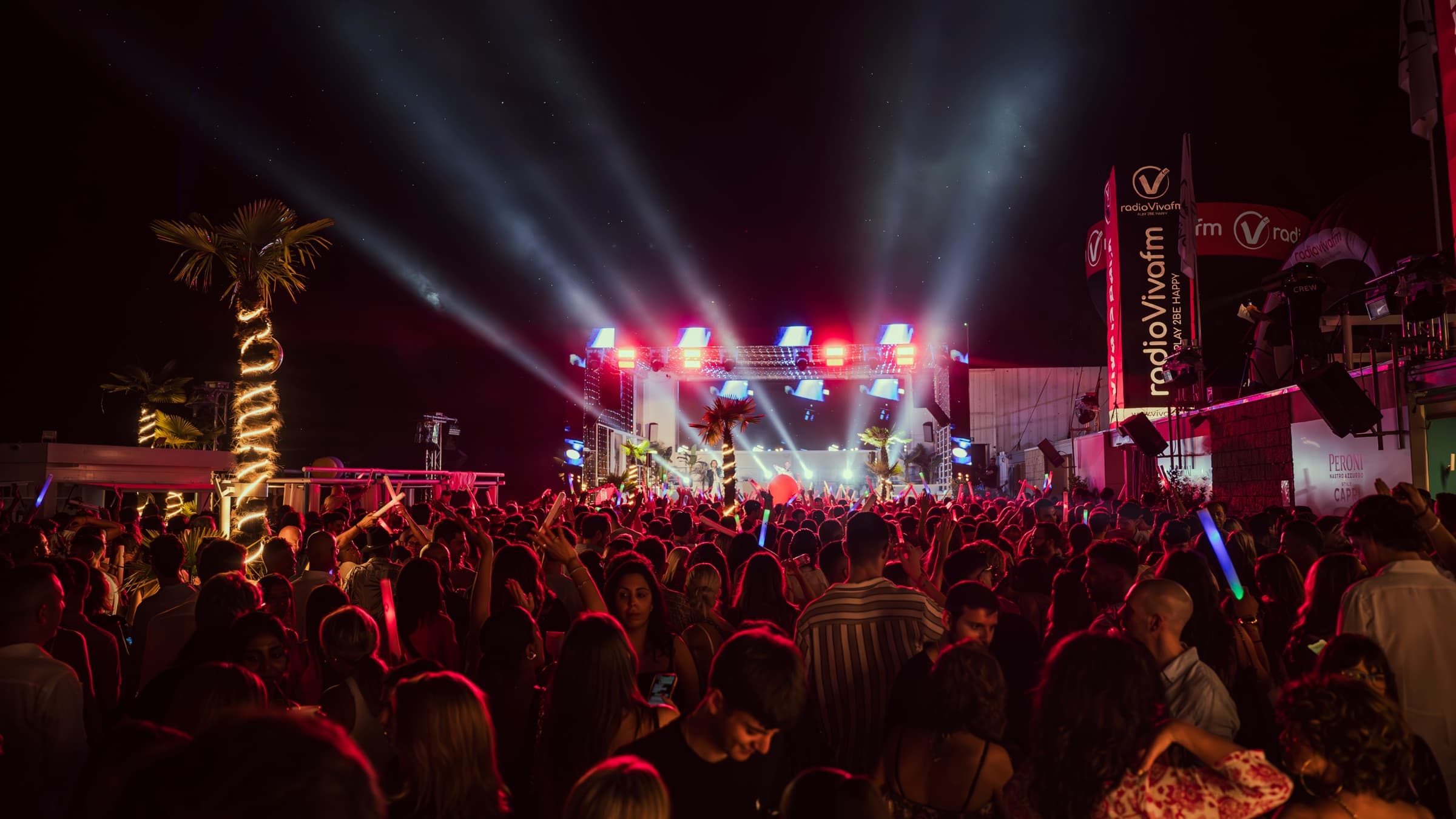 Palco con fasci di luce e folla in festa durante Viva is Back di Radio VivaFm al Coco Beach Club