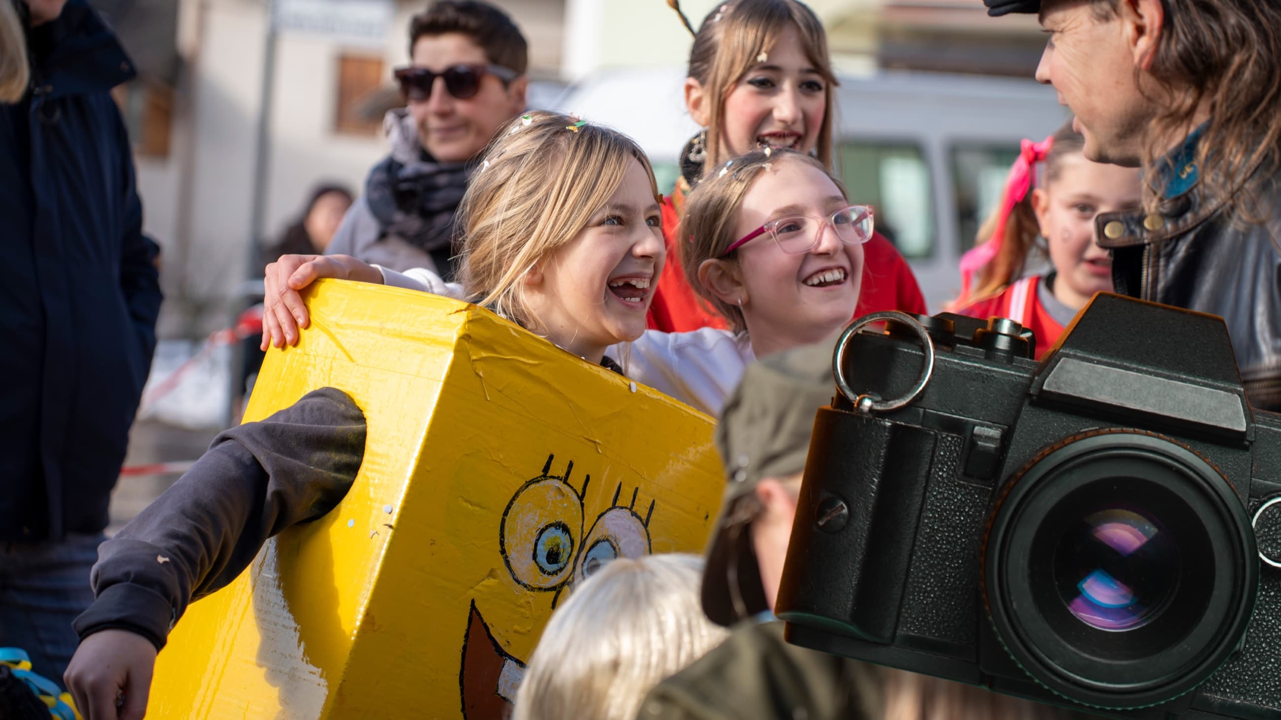Ritratto rubato durante il Carnevale: due bambine ridono davanti all'obiettivo