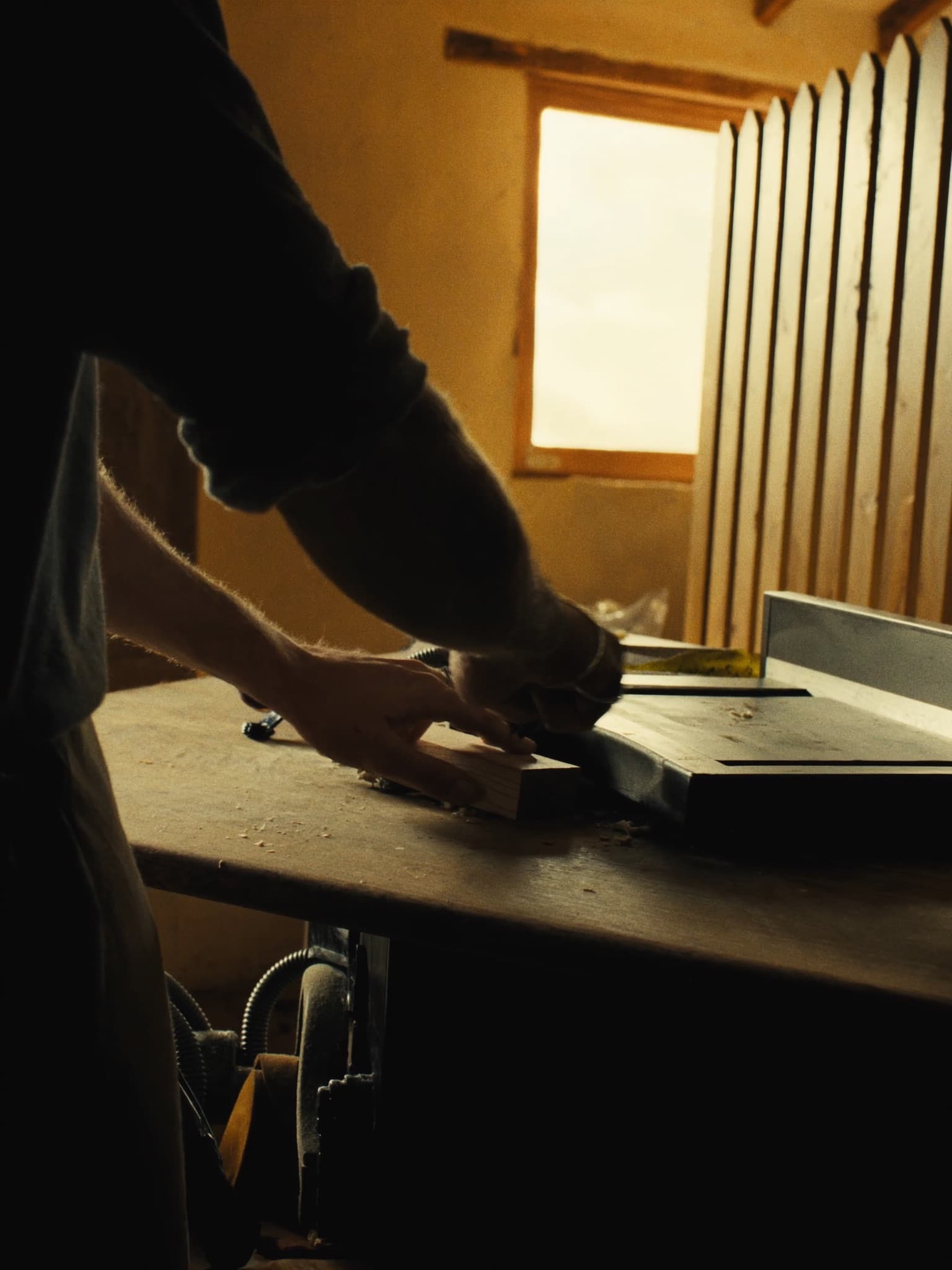 Un artigiano al lavoro su un pezzo di legno nel suo laboratorio