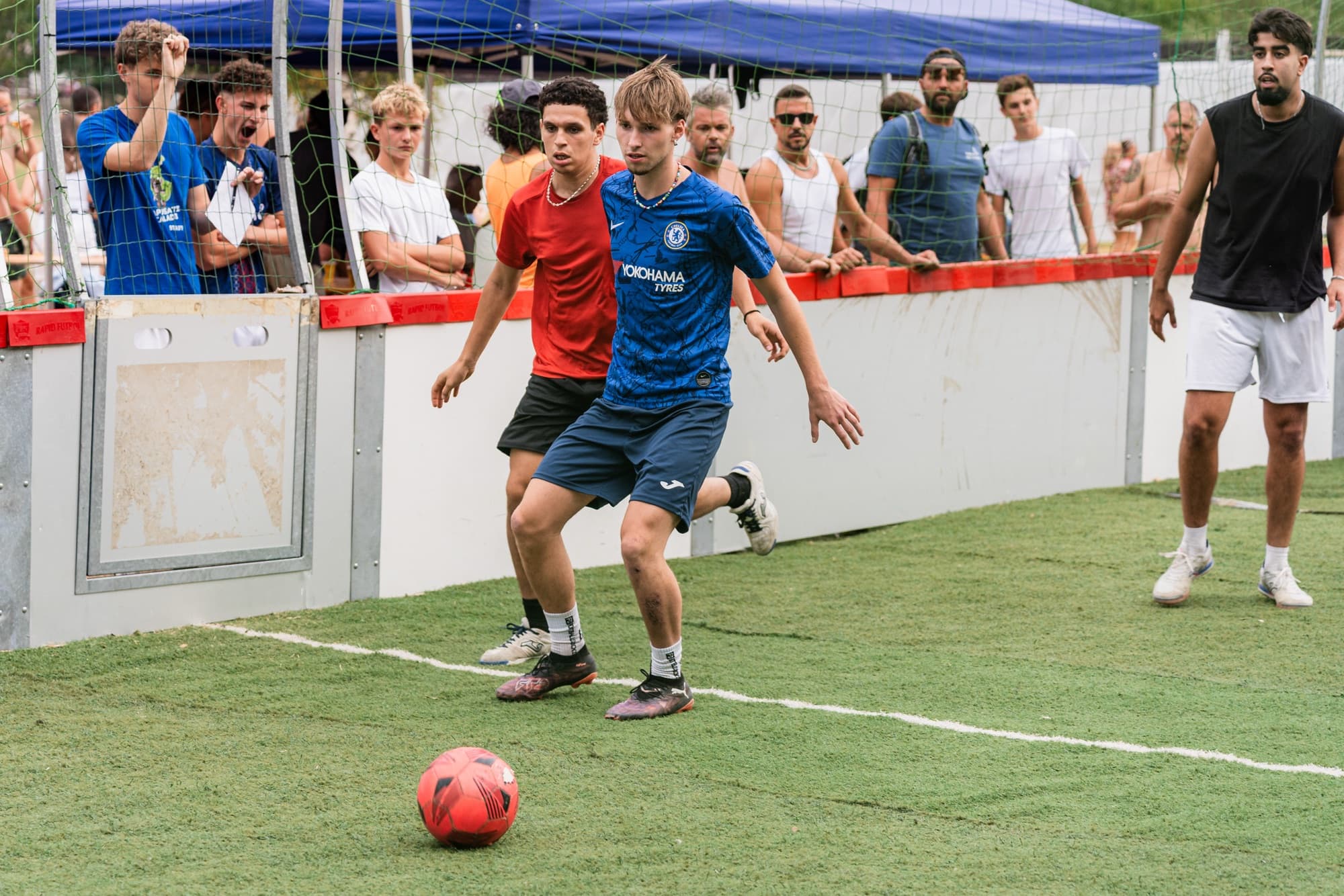 Una partita di calcio a 5 serale, con il pubblico che segue da bordo campo