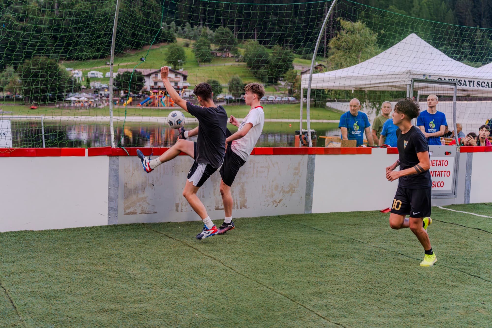 Giocatori in azione durante una partita di calcio a 5 in riva al lago
