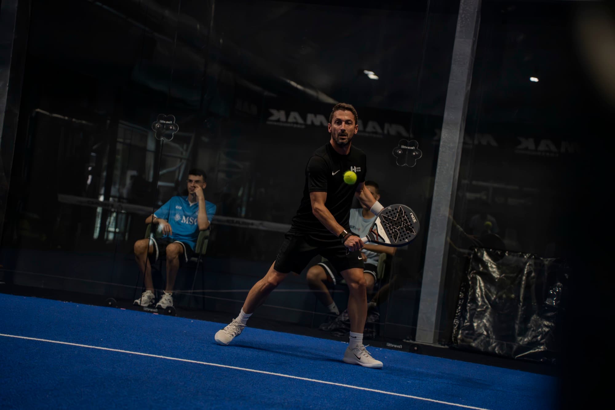 Un giocatore di padel colpisce la palla durante una partita