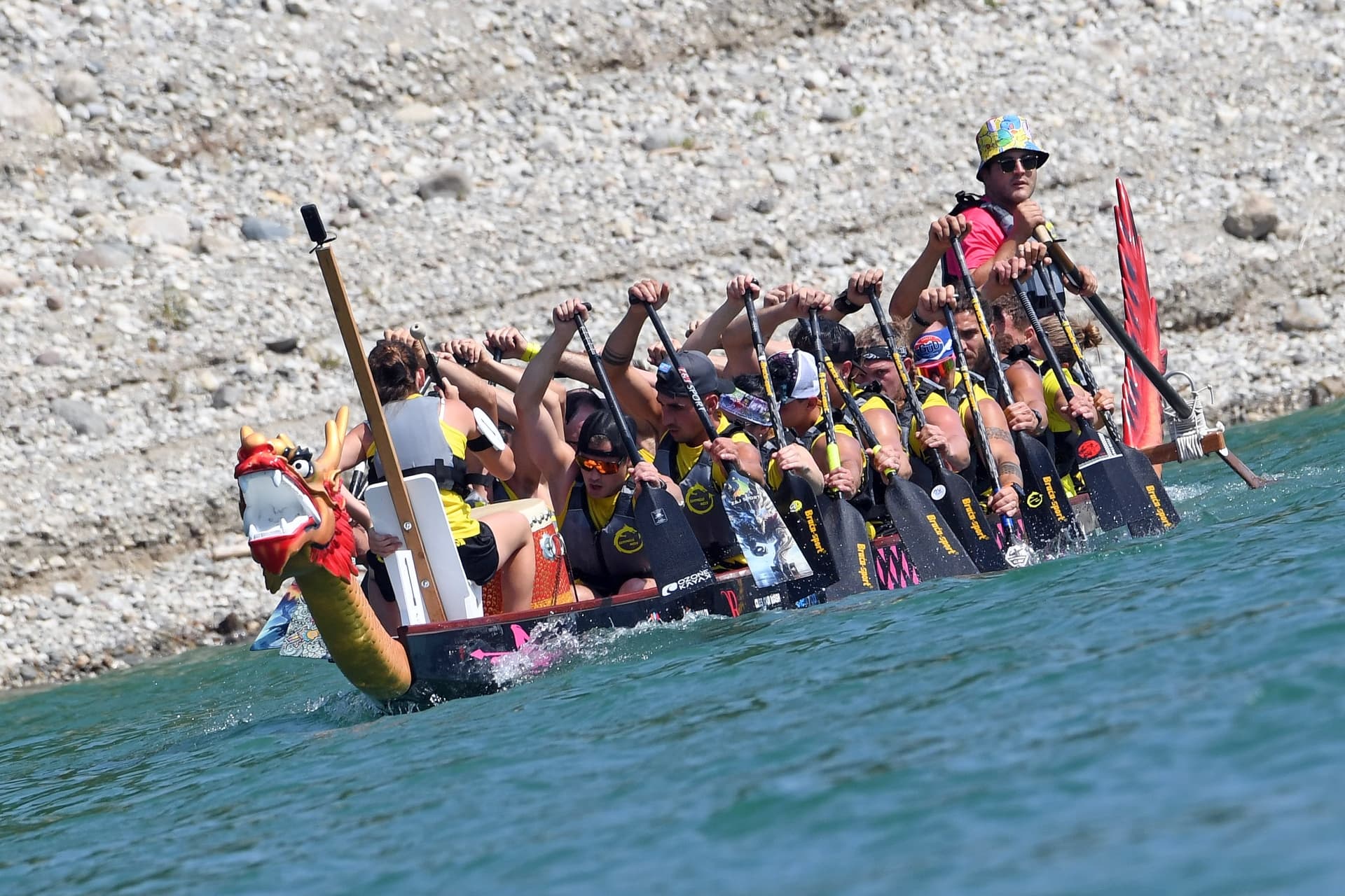 Equipaggio di dragon boat in piena competizione a remi, ripreso dall'alto durante il DragoNosa