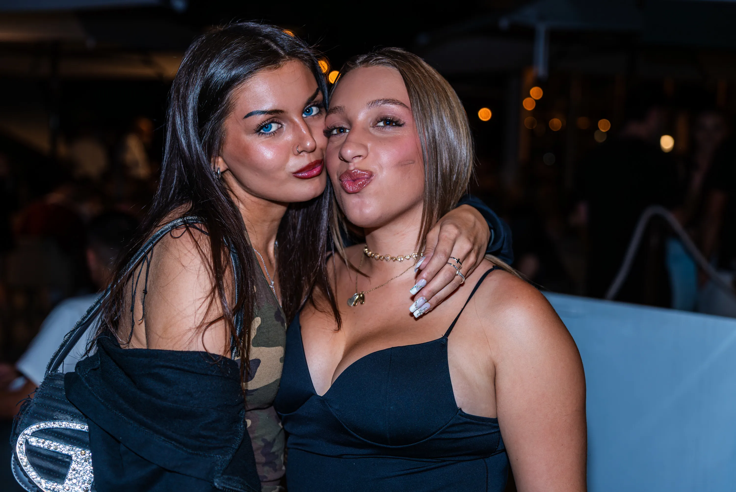 Due ragazze posano abbracciate a fine serata