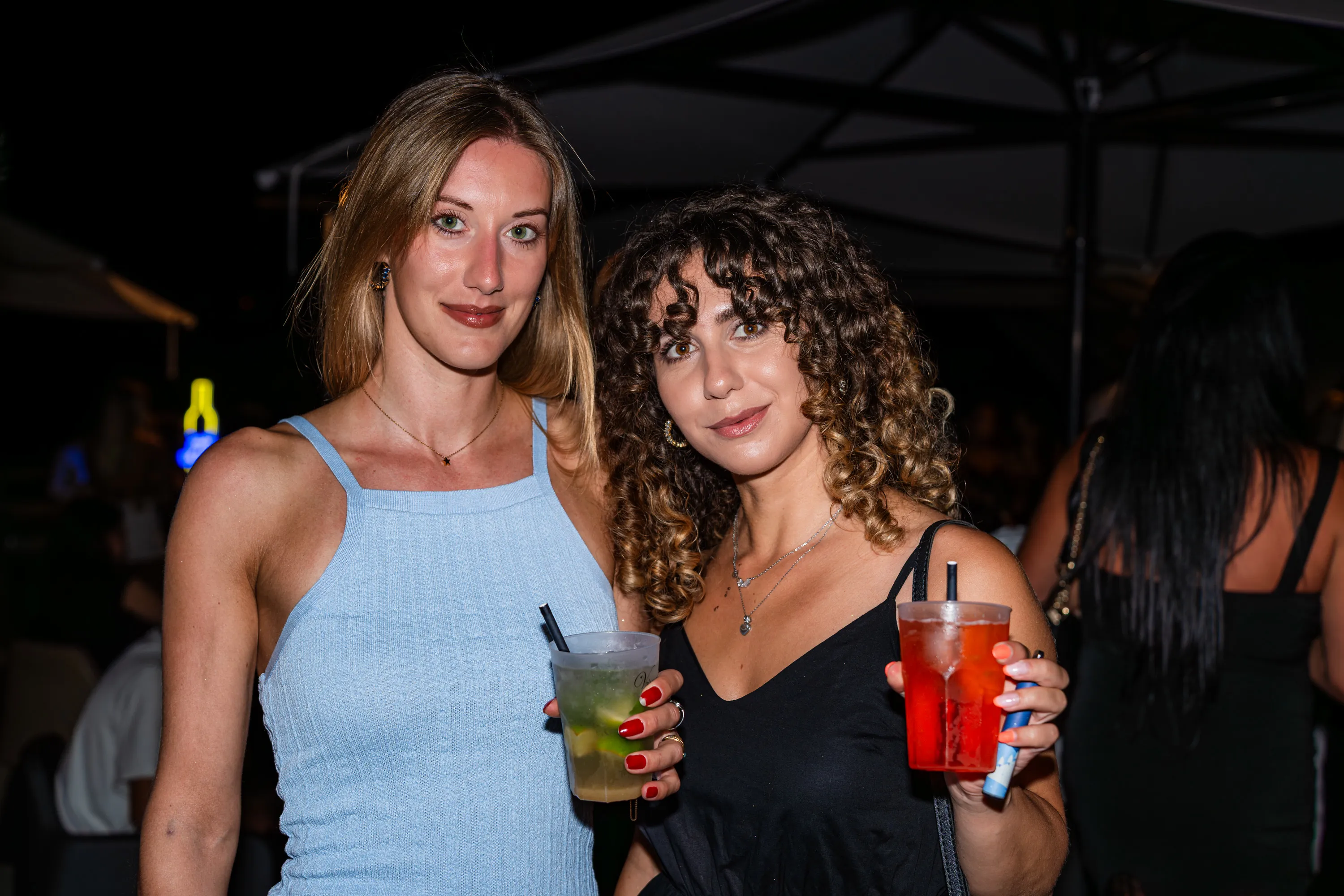 Due ragazze con i drink in mano durante la serata