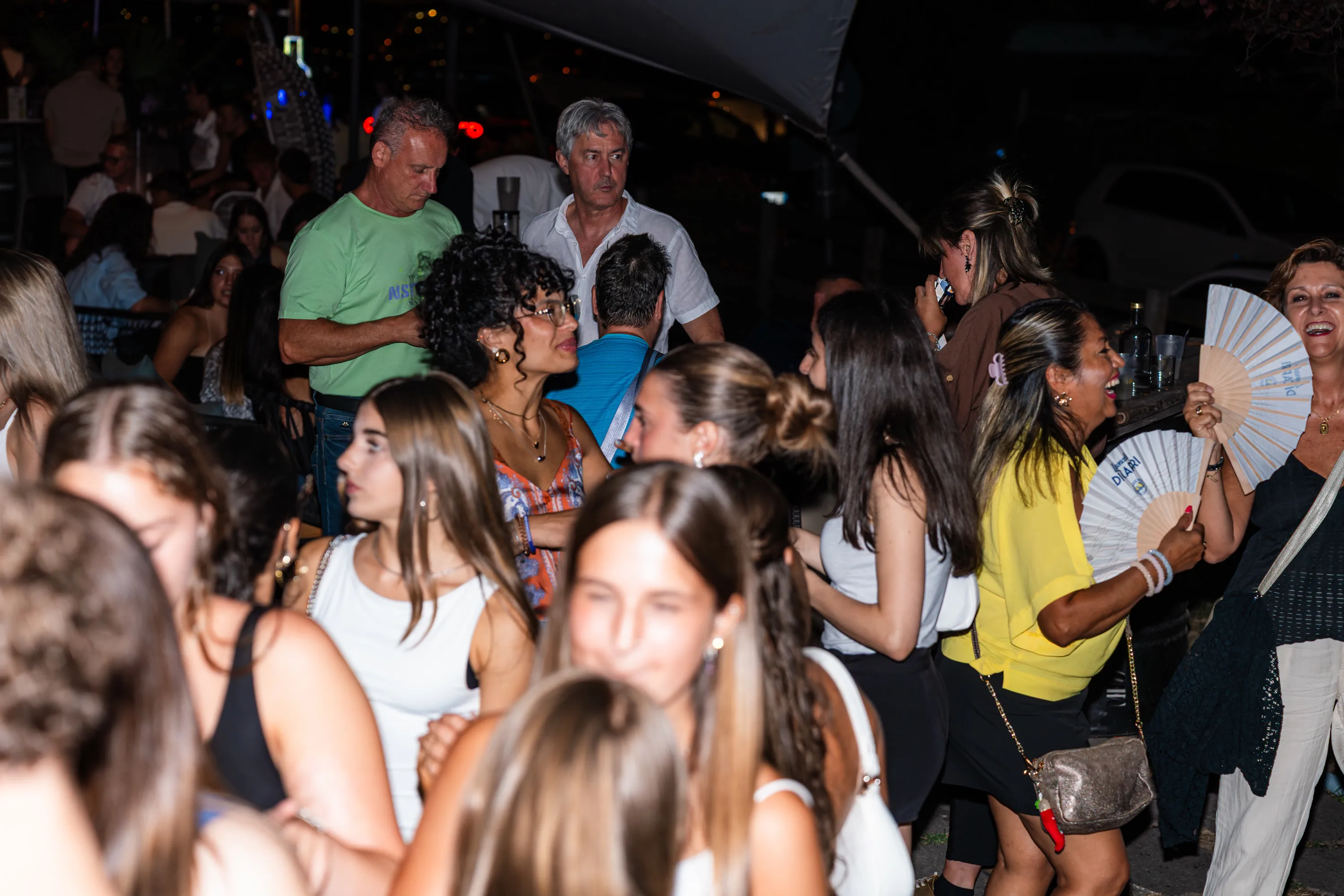 La folla con i ventagli aperti durante la serata
