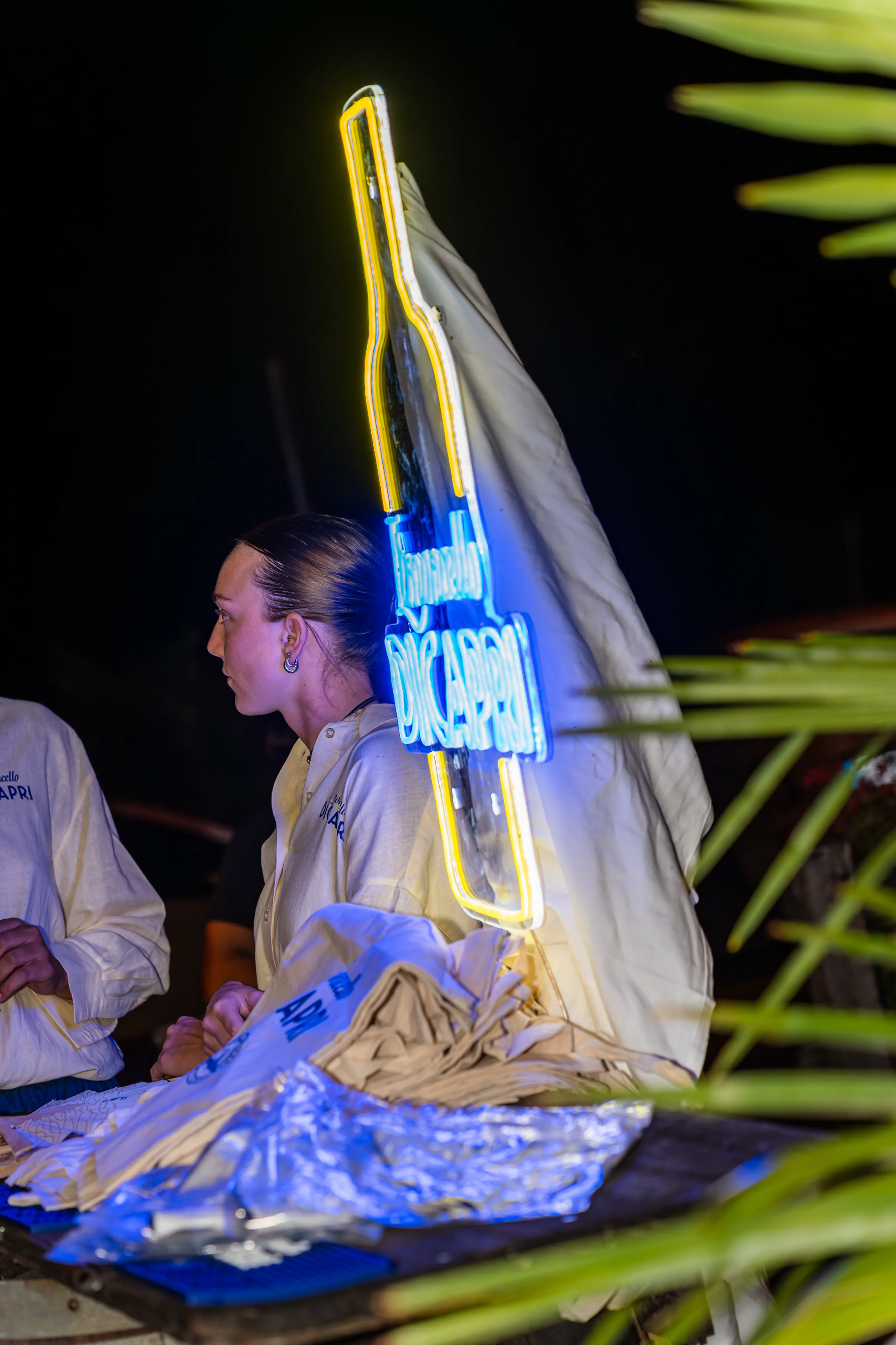 Una ragazza davanti all'insegna al neon del Limoncello di Capri, accesa nella notte