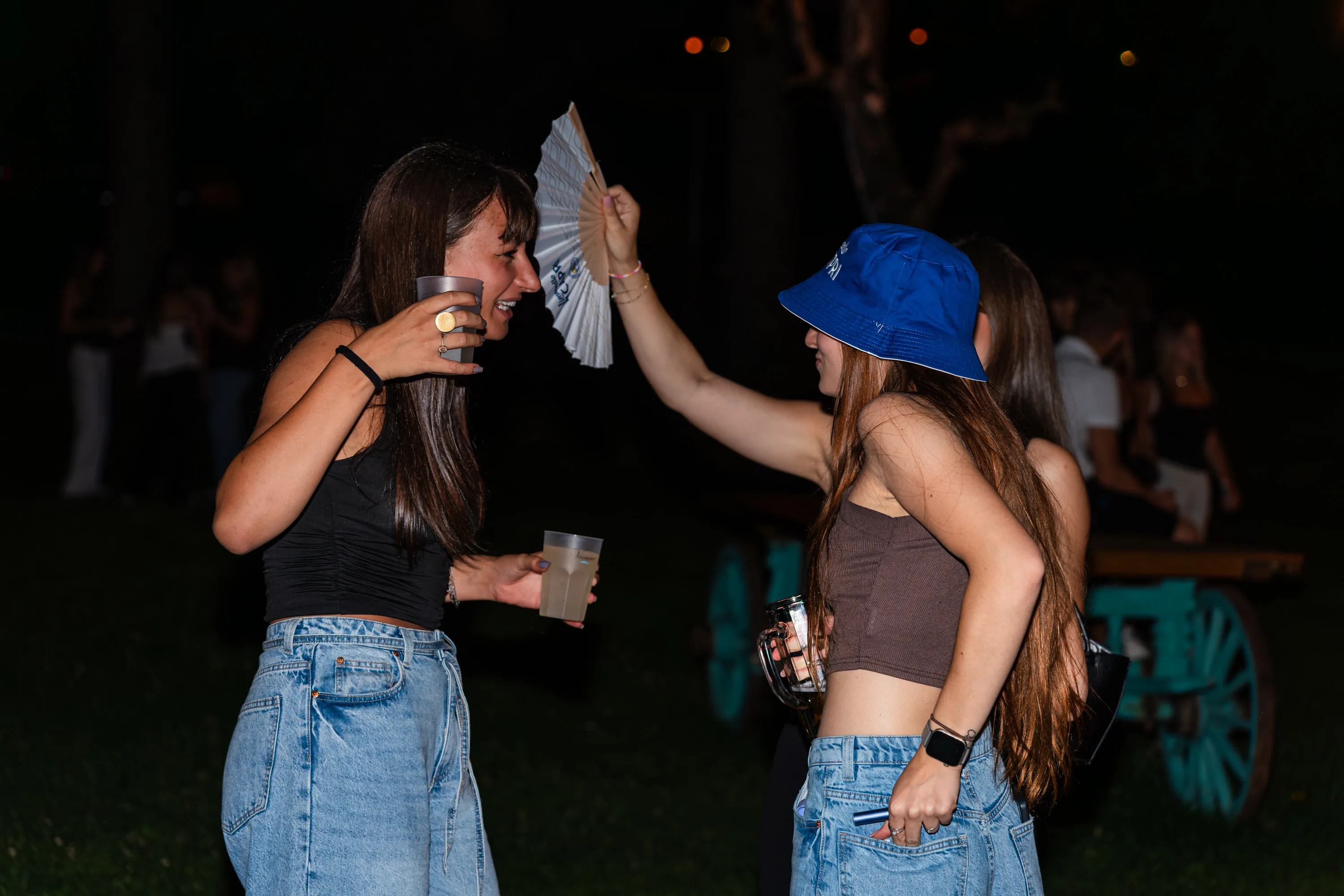 Due ragazze con il ventaglio sul prato accanto al locale