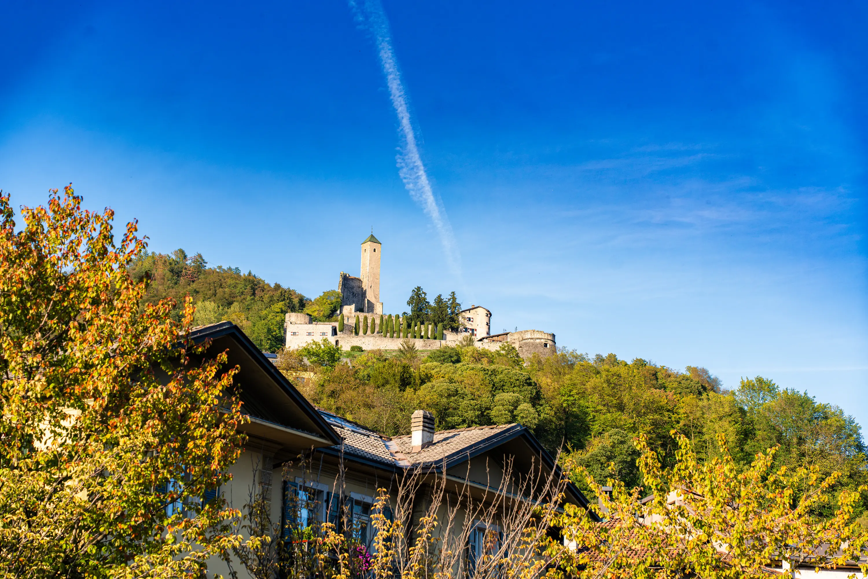 Il castello sulla collina sopra le case, fra gli alberi d'autunno