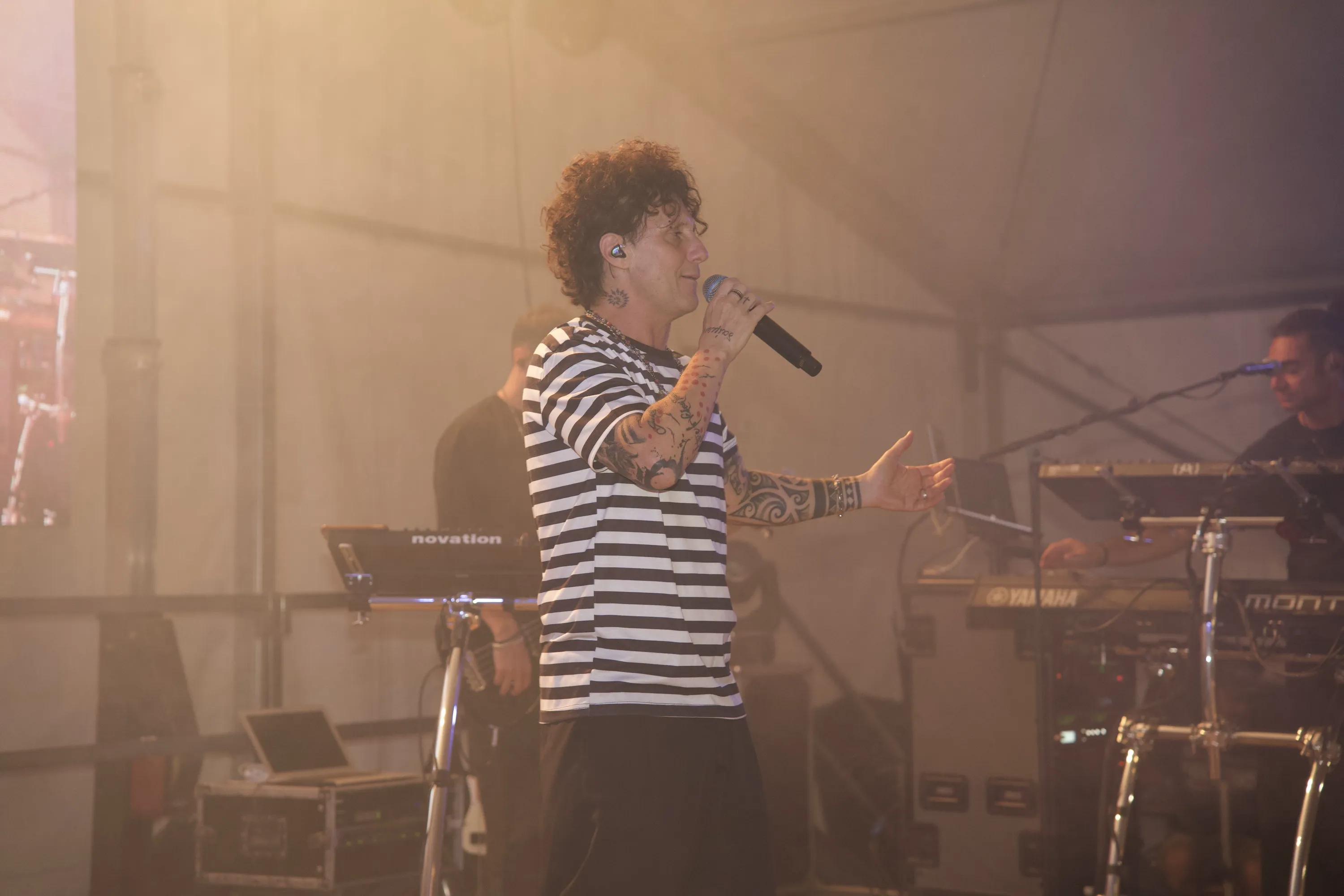 Il cantante della band al microfono, nel fumo caldo del palco