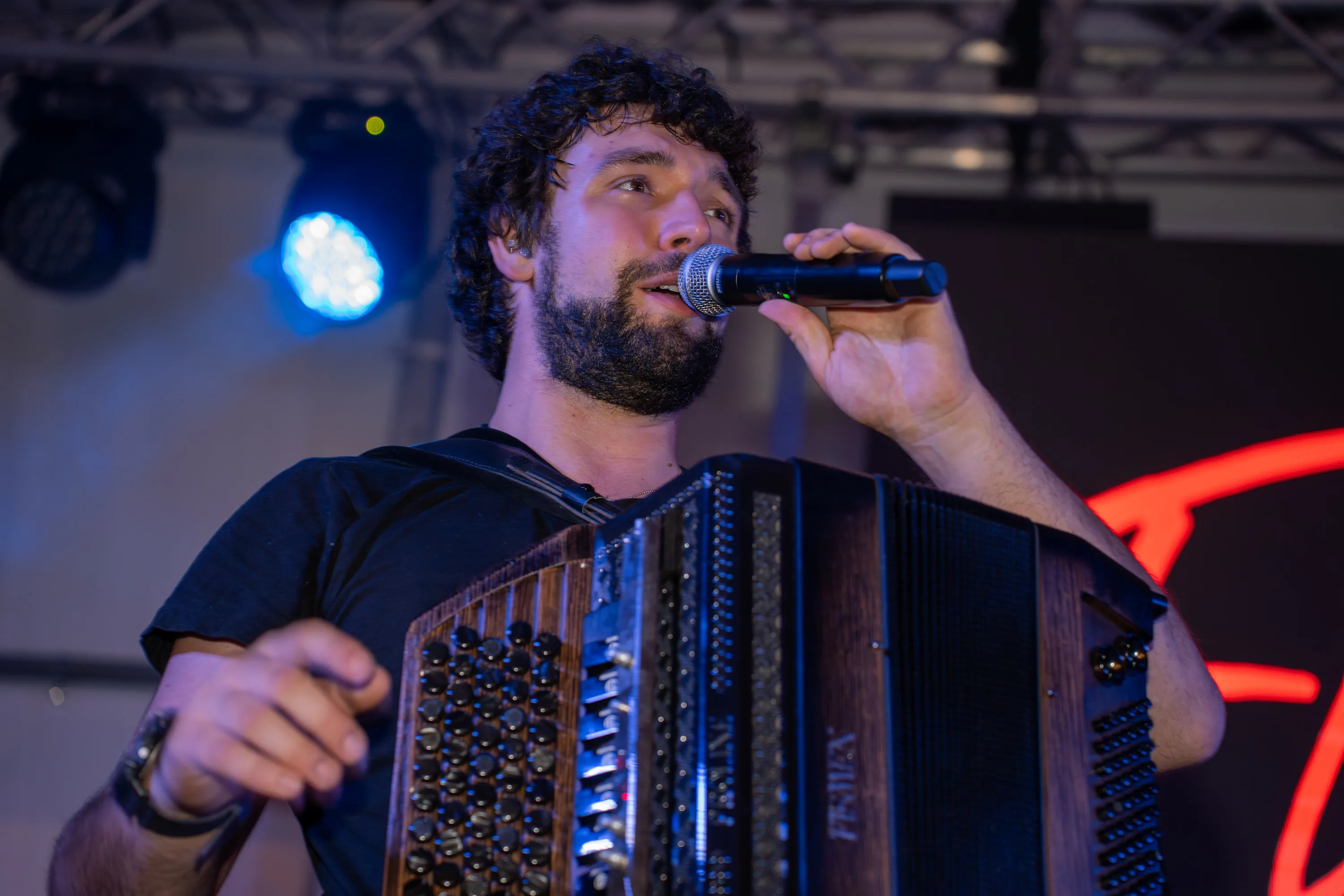 Il fisarmonicista canta al microfono durante il concerto della prima sera