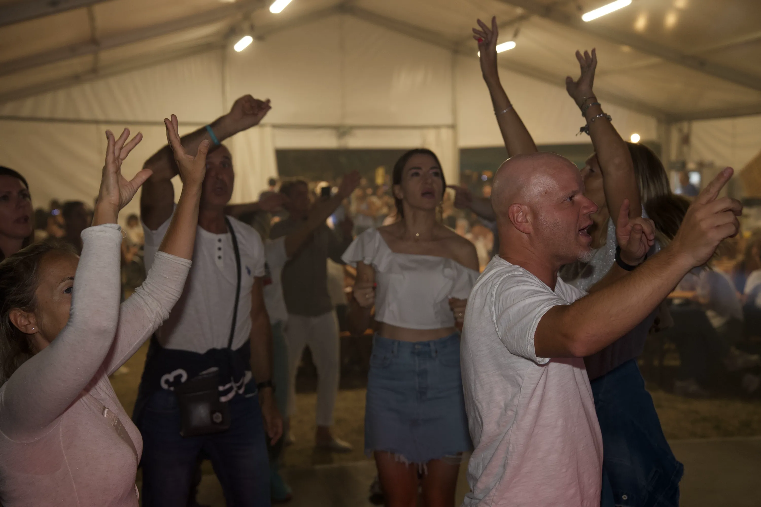 Il pubblico con le mani alzate sotto il tendone