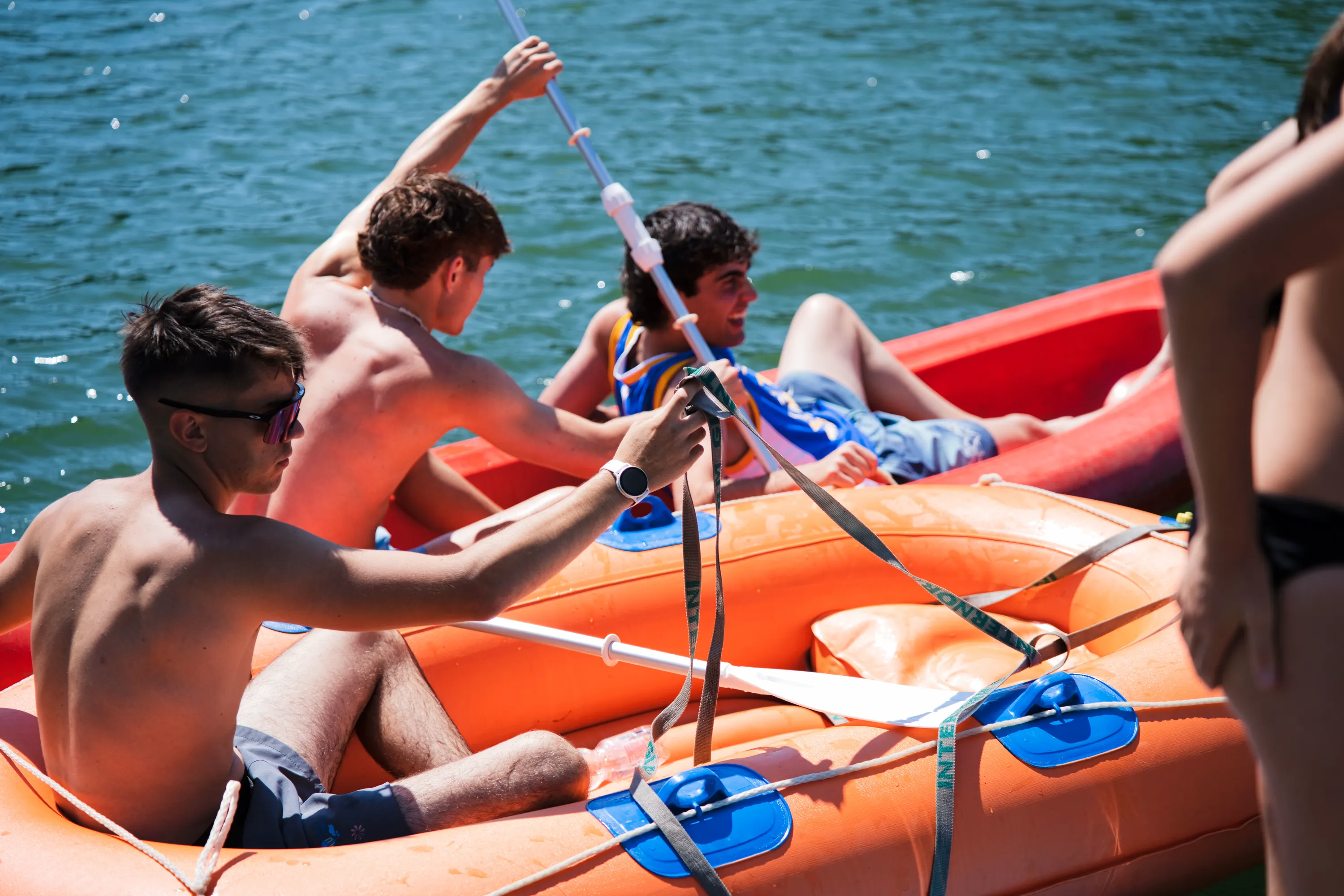 Un gruppo di ragazzi rema su un gommone con le pagaie