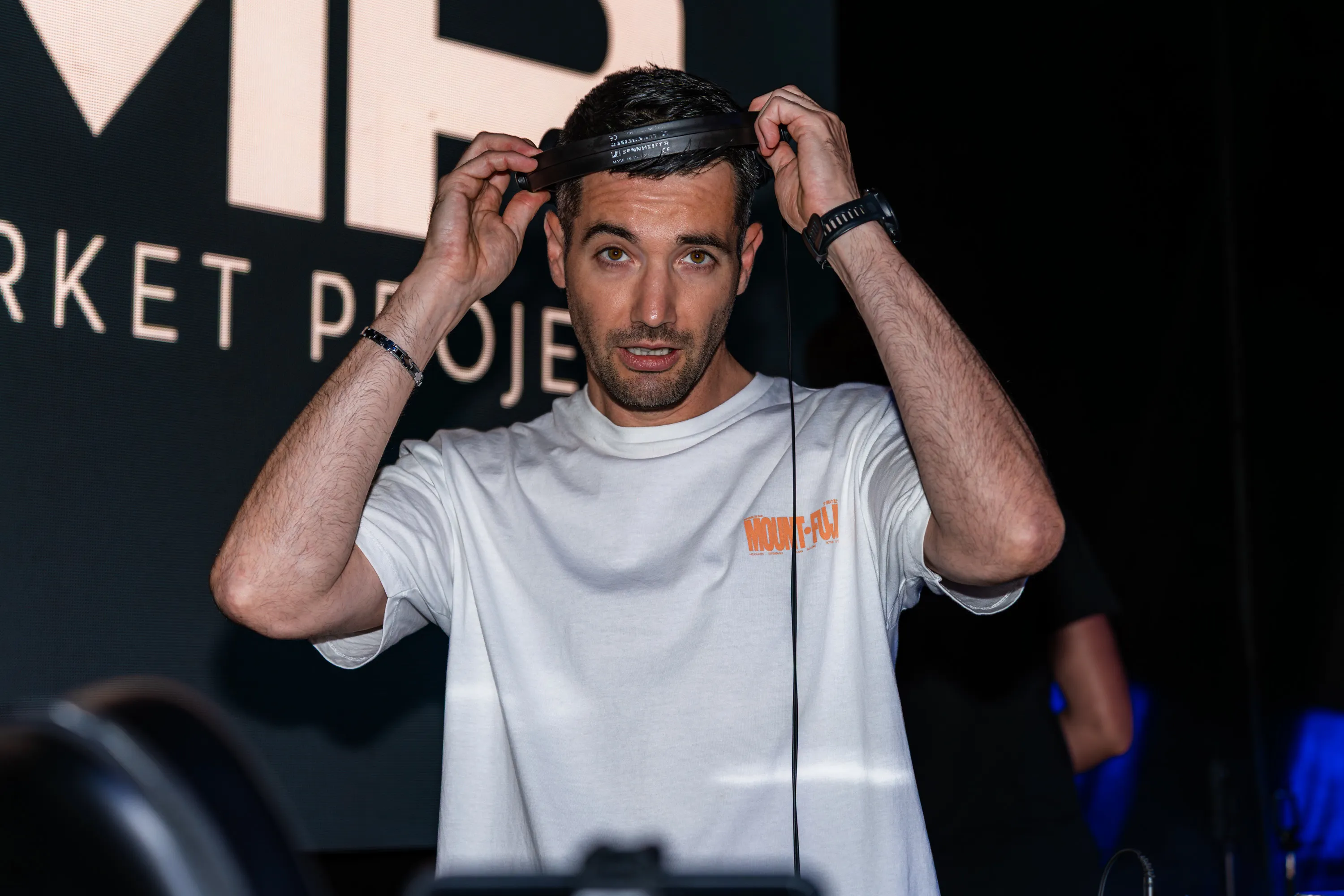 Il dj si sistema le cuffie sul palco, di notte