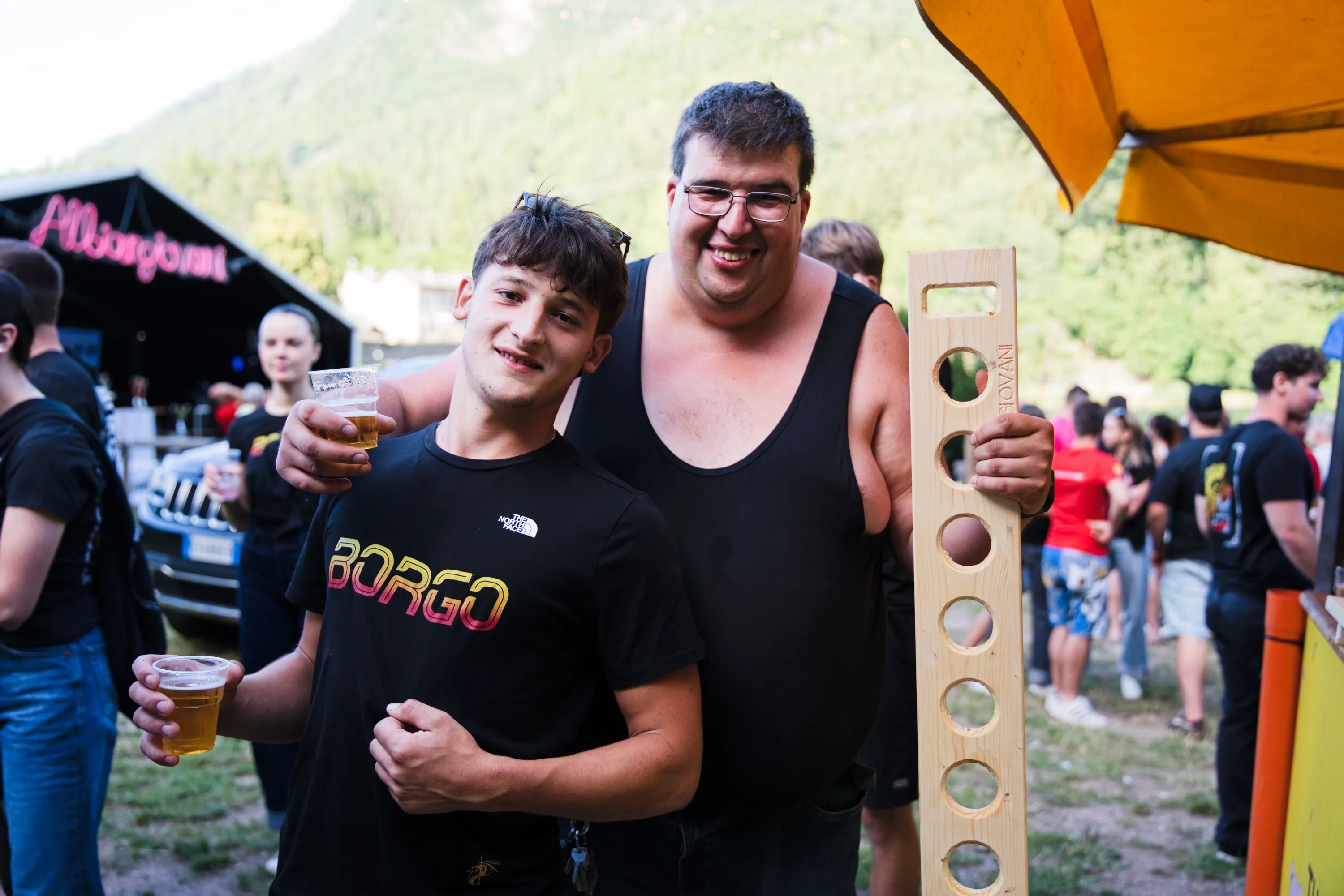 Due uomini sorridono con il bicchiere in mano a fine giornata