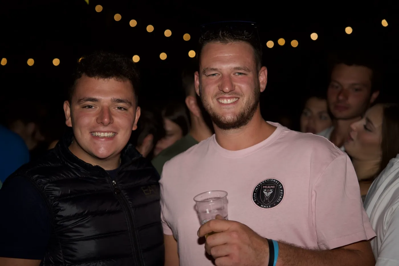 Due ragazzi alla festa serale, sotto le lucine