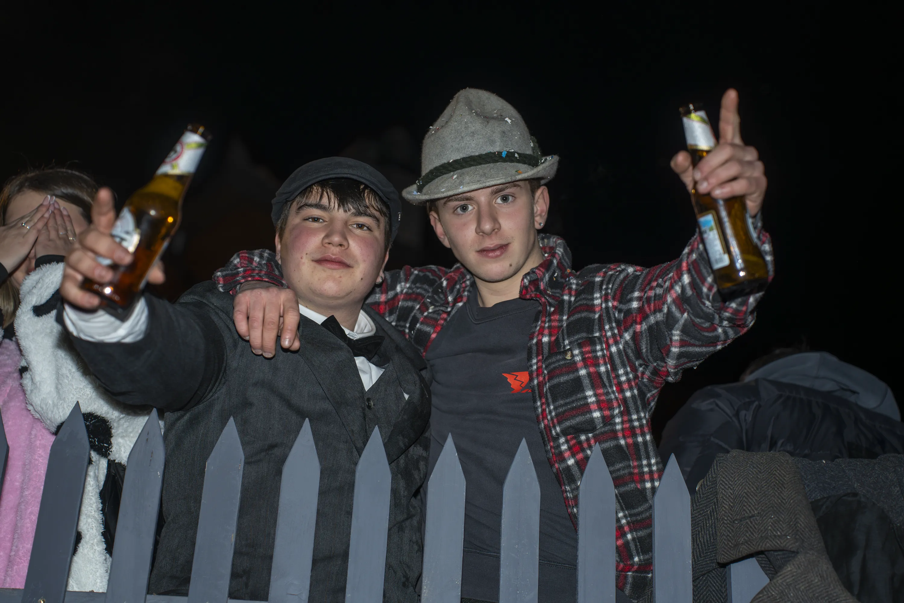 Due ragazzi con il cappello tirolese alzano le bottiglie di birra