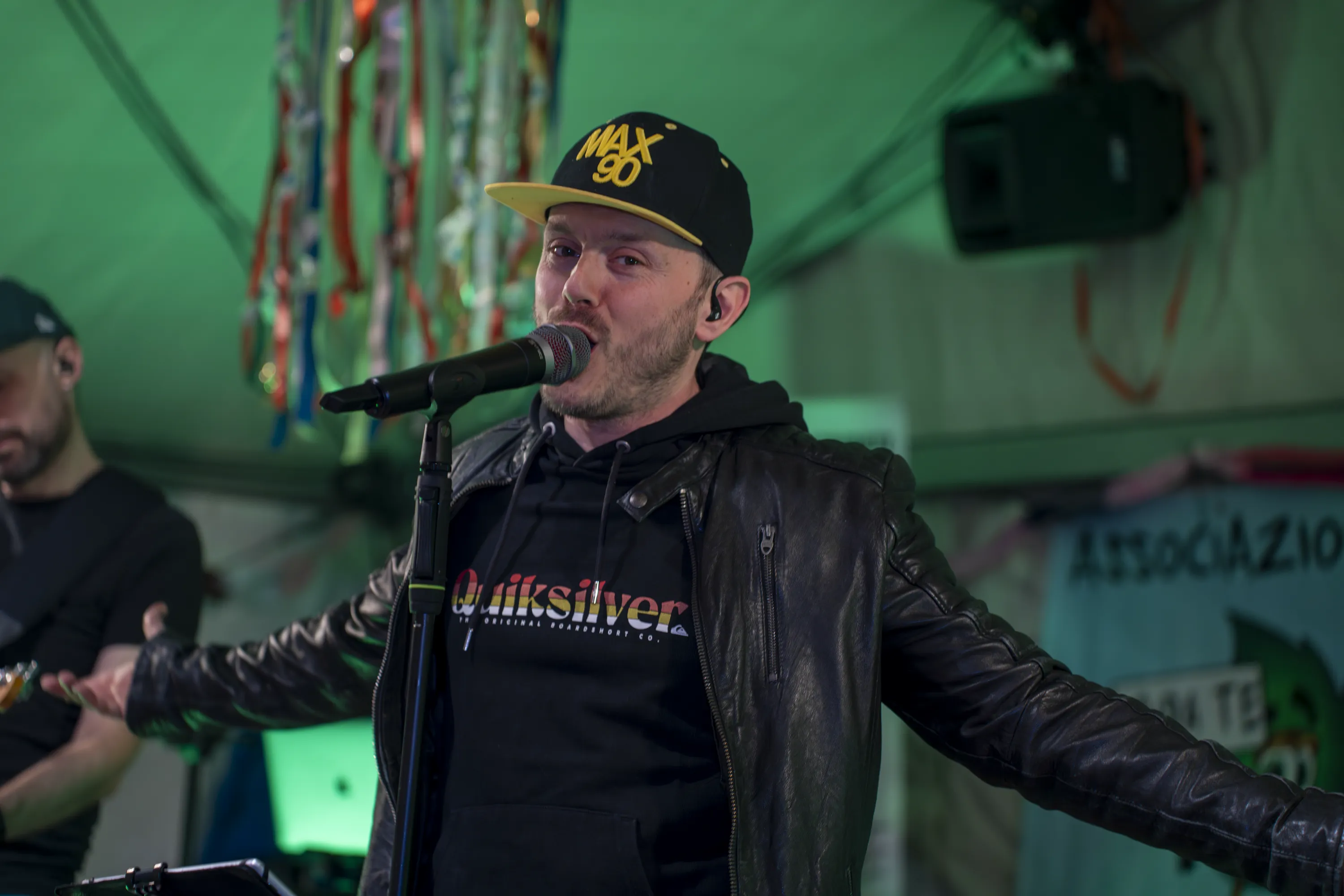 Il cantante al microfono nella luce verde del palco, la seconda sera