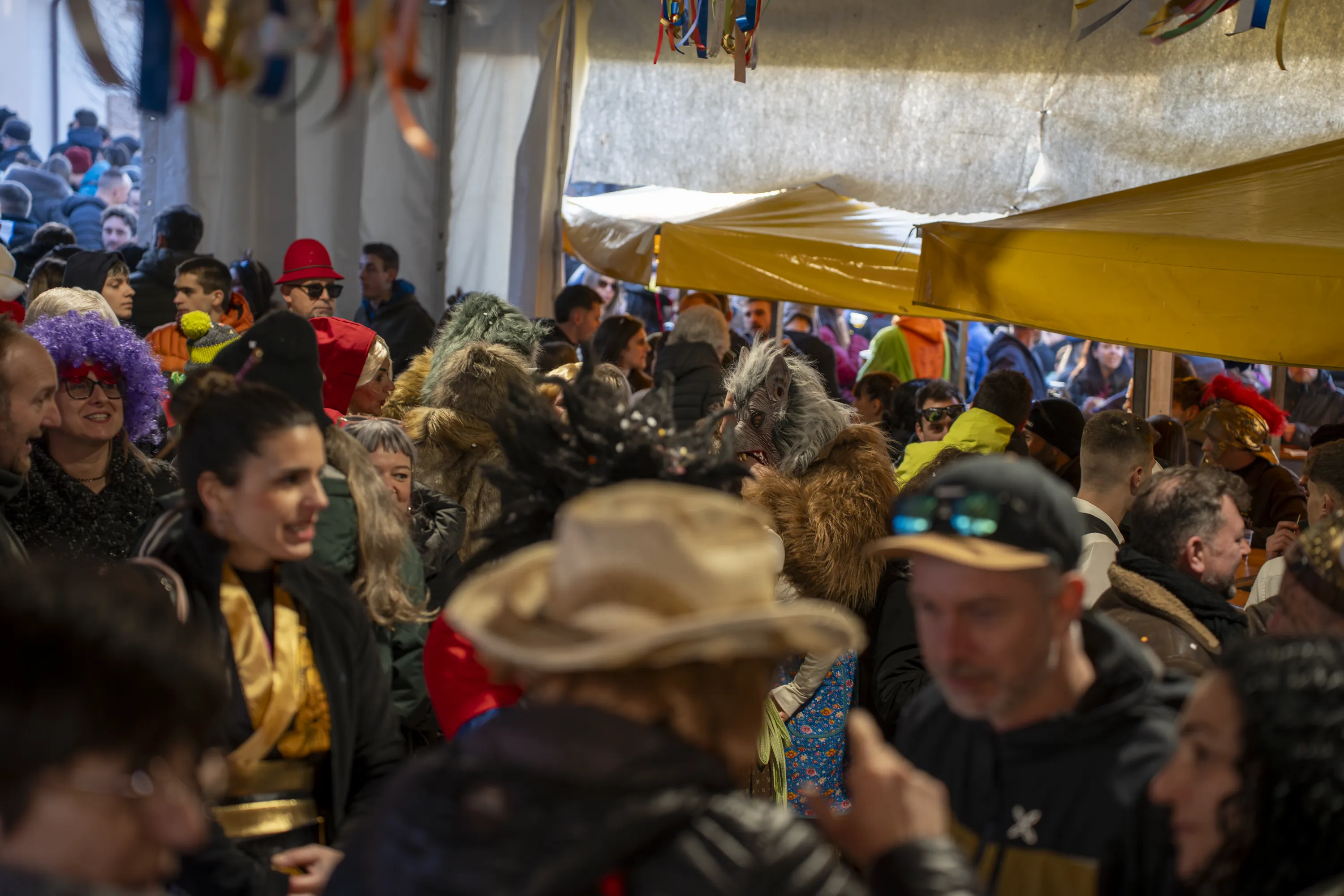 La folla sotto i gazebo gialli lungo la via, di giorno