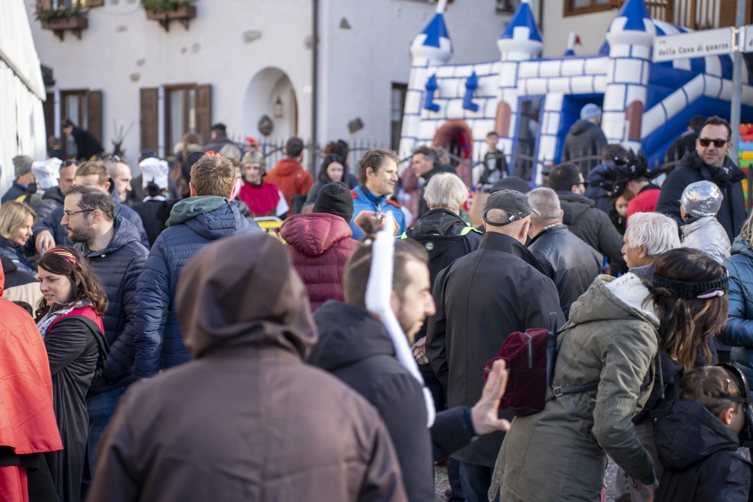 La via del paese durante il Carnevale, con il castello gonfiabile e le montagne sullo sfondo
