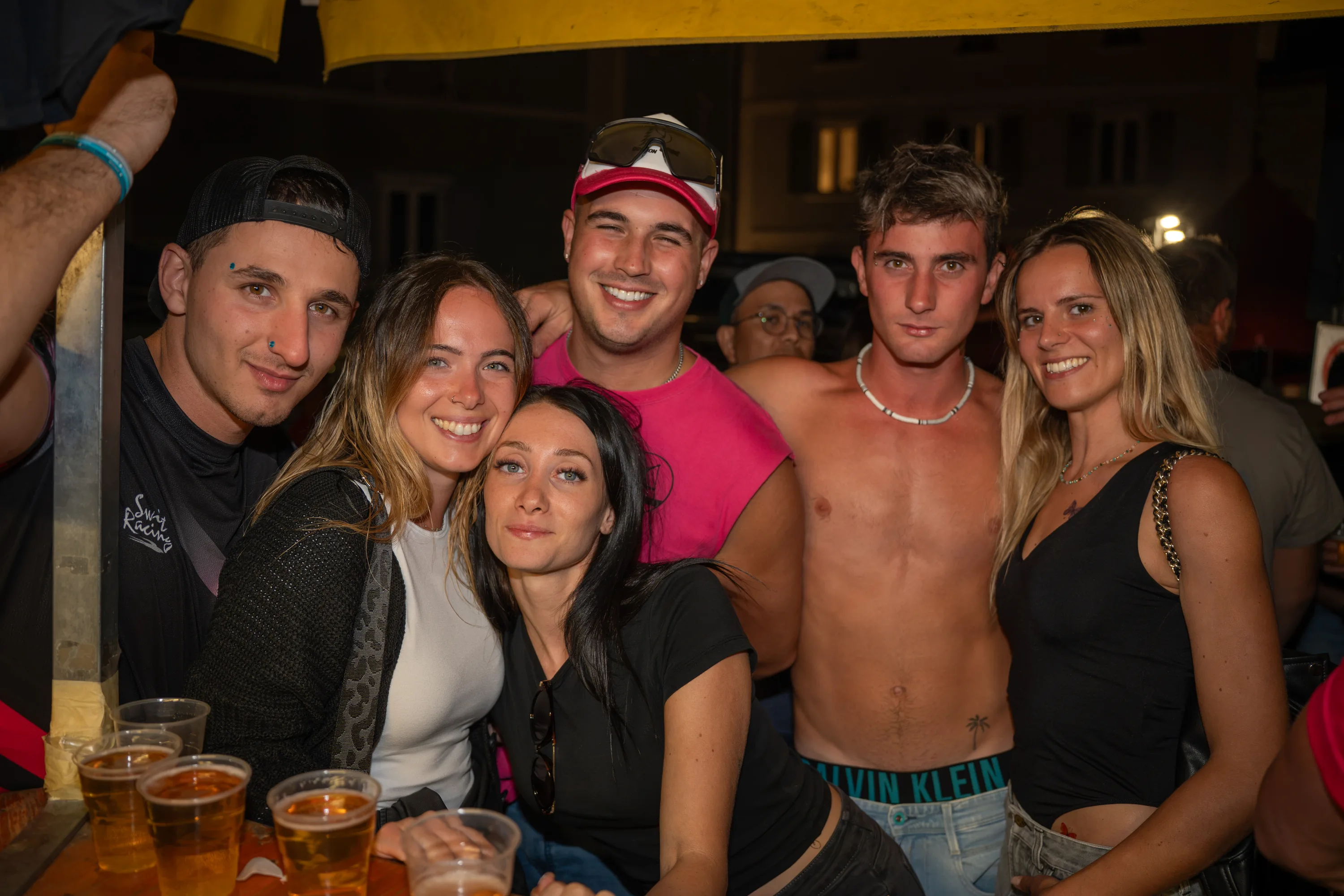 Un gruppo di amici in posa al banco, con i bicchieri di birra davanti
