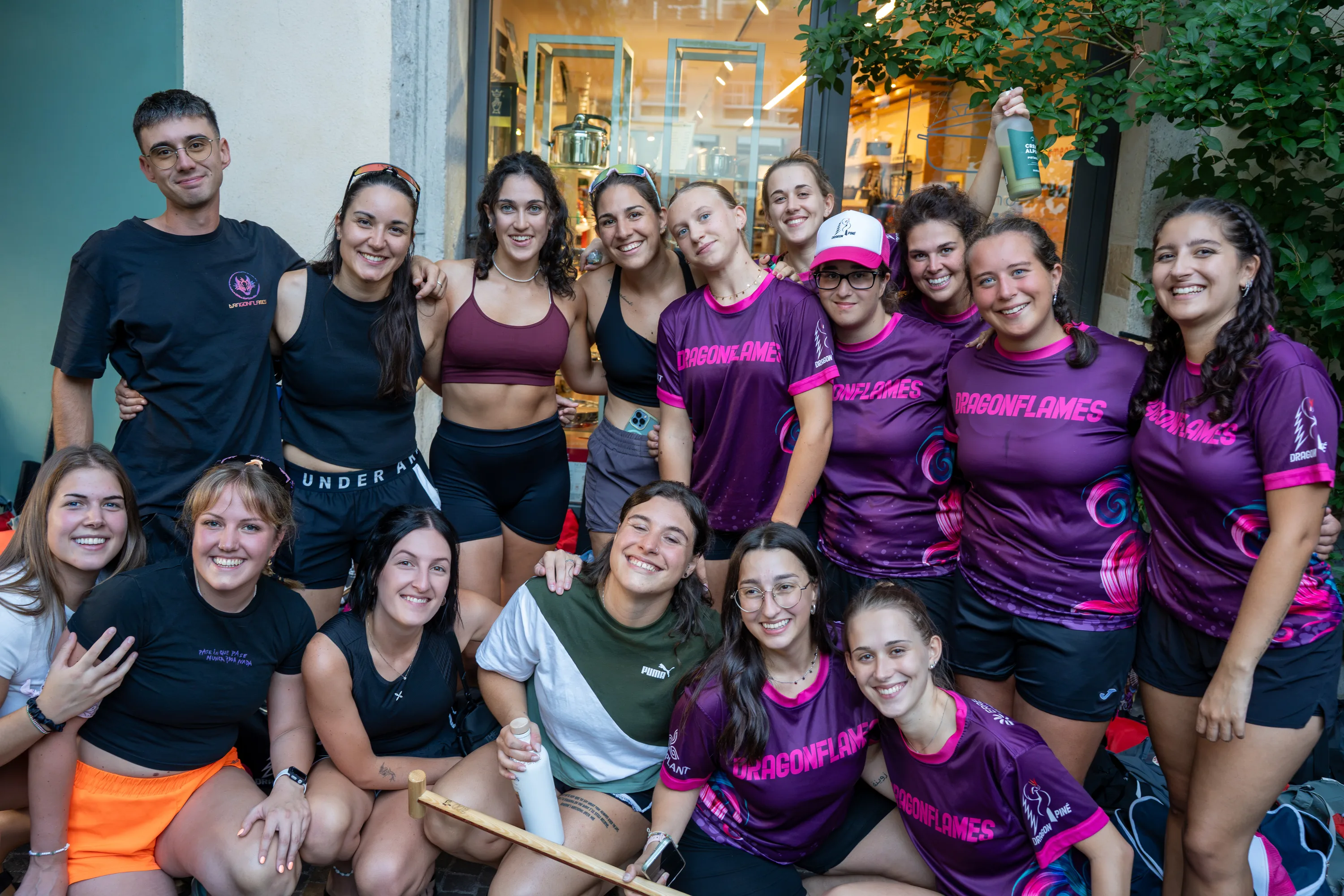 Una squadra in maglia viola e nera in posa tutta insieme davanti a una vetrina
