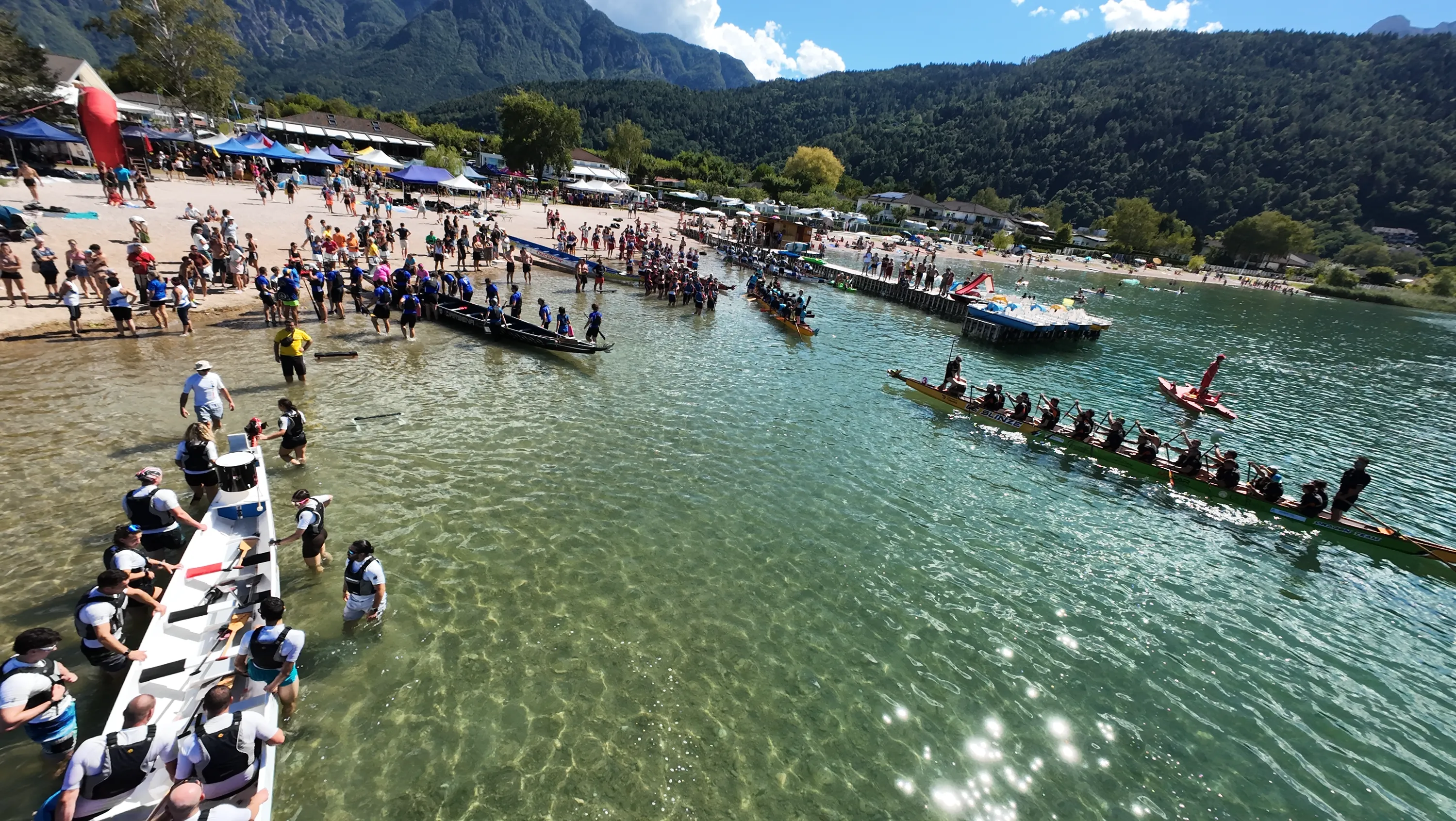 Le barche ormeggiate lungo la riva e il pubblico sulla spiaggia, visti dall'alto