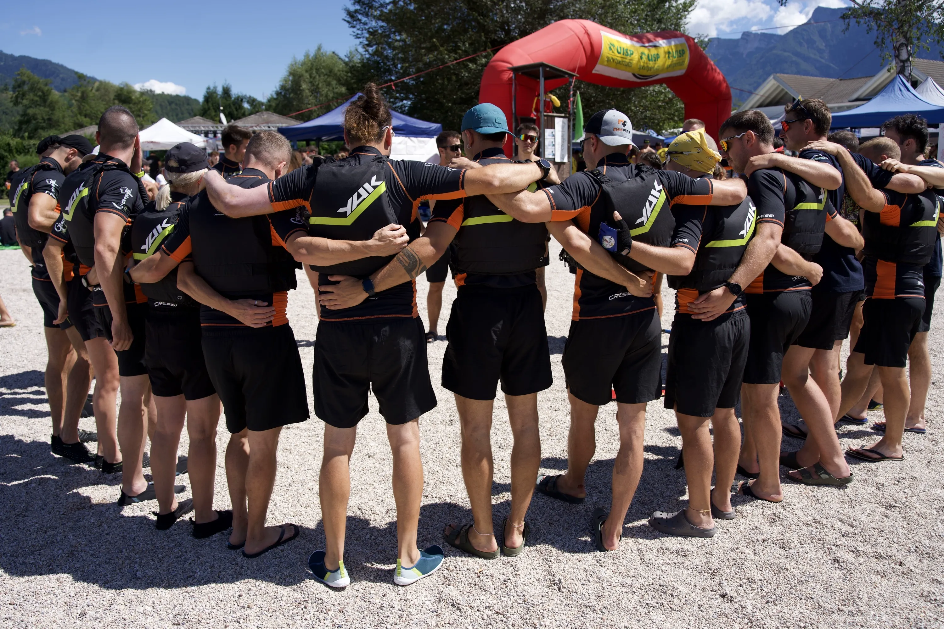 Una squadra in maglia nera riunita in cerchio sulla spiaggia prima della gara