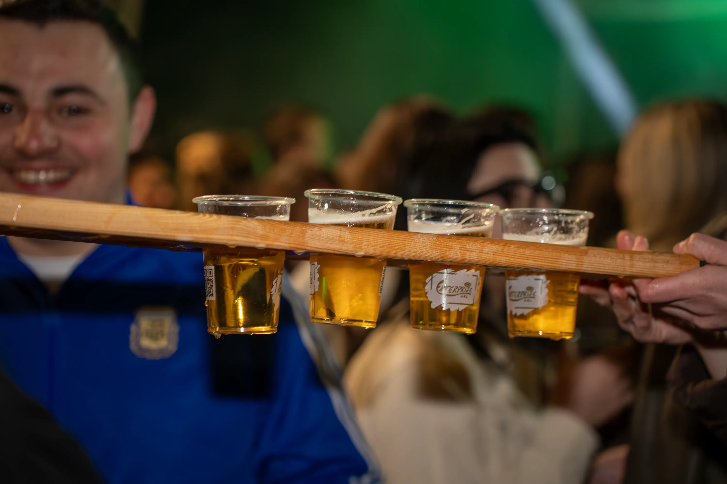 Un uomo attraversa la folla con un vassoio di birre