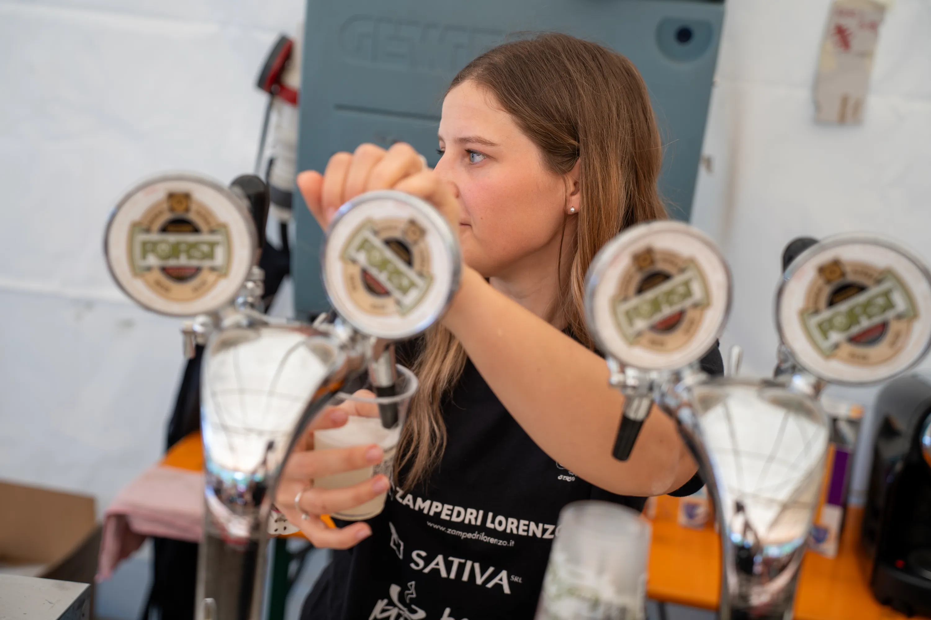 Una ragazza spilla la birra al banco della sagra