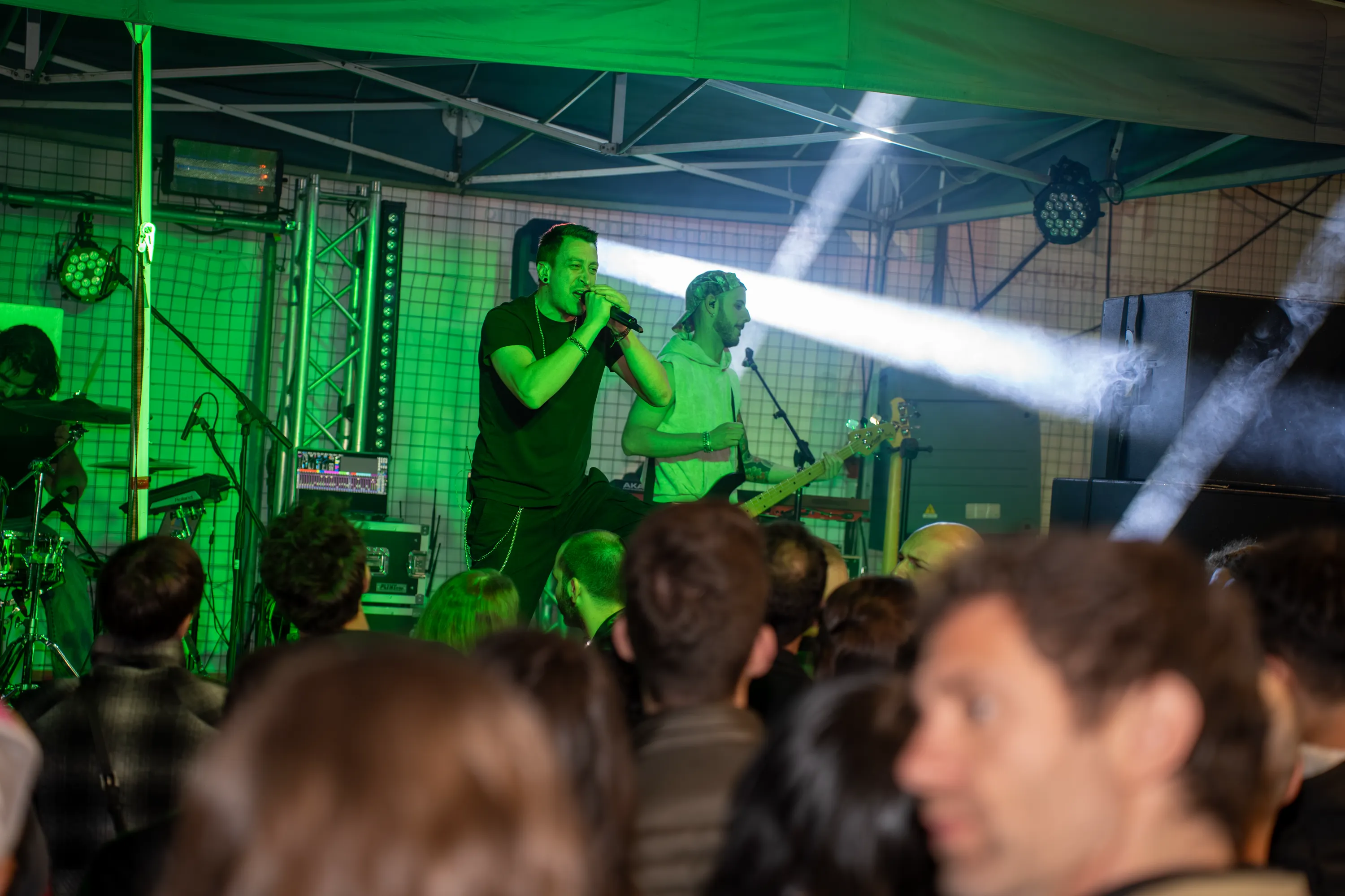 Il dj alla consolle nella luce verde del palco