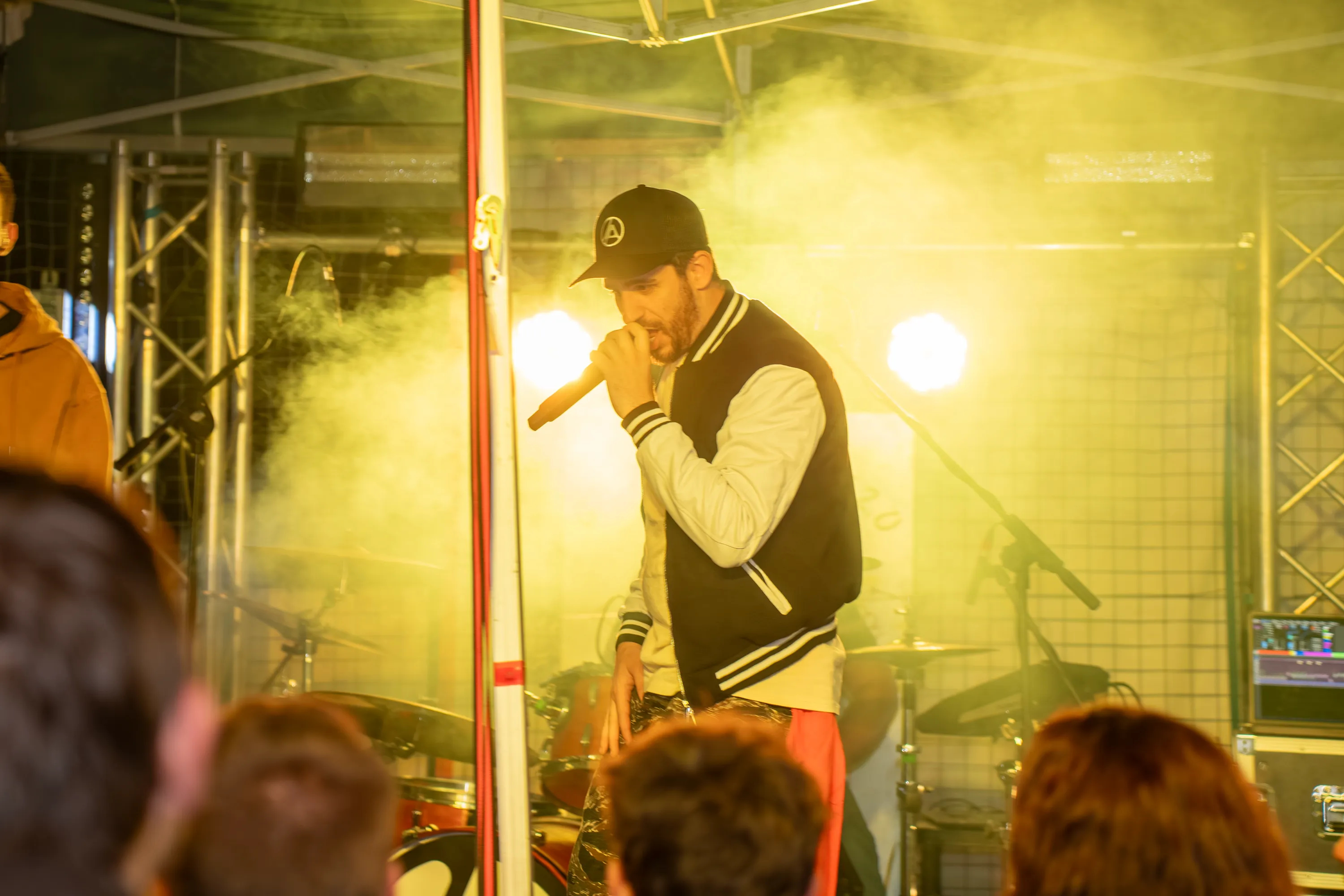 Il cantante al microfono dentro il fumo giallo dei fari