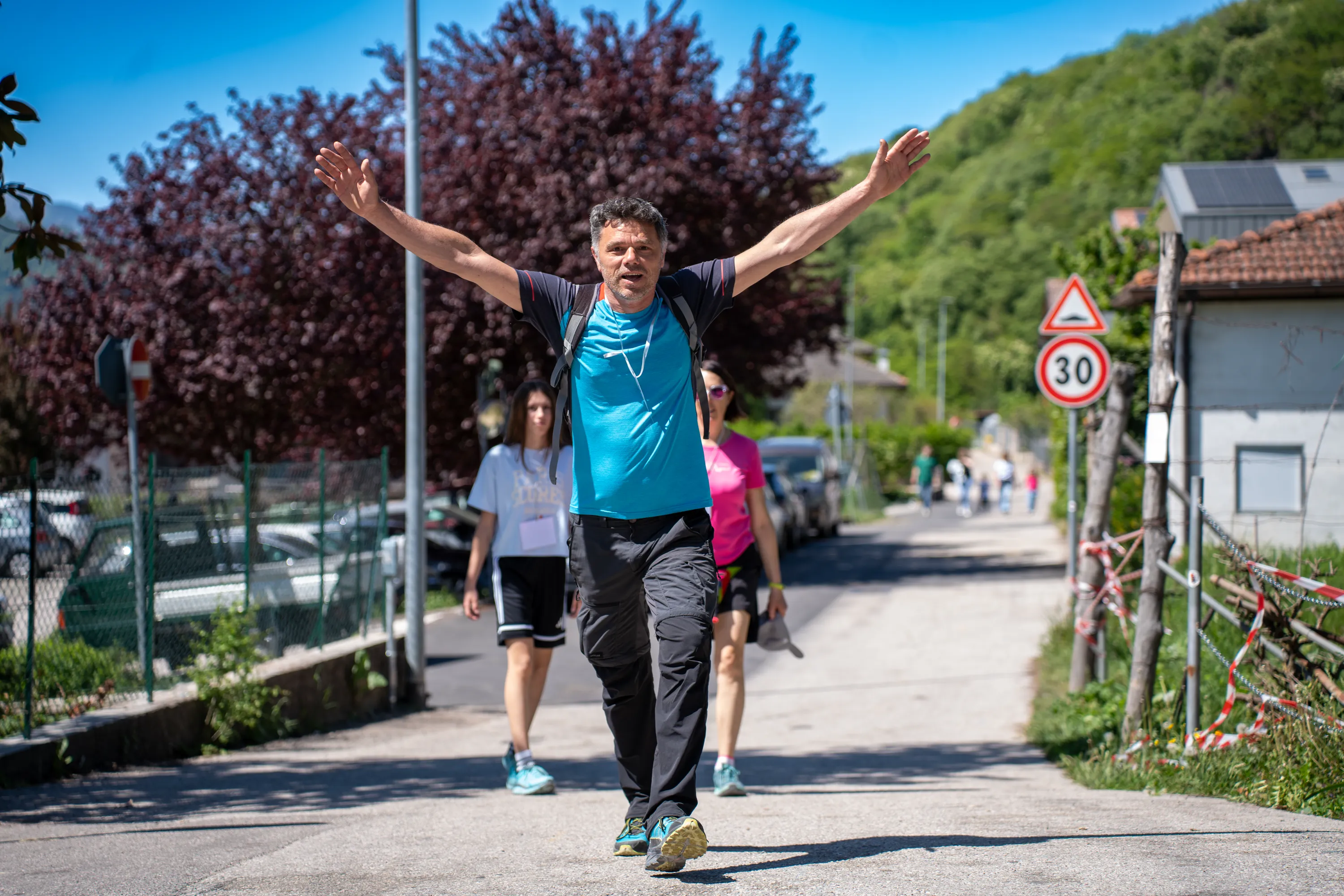 I partecipanti alla marcia camminano lungo la strada del paese