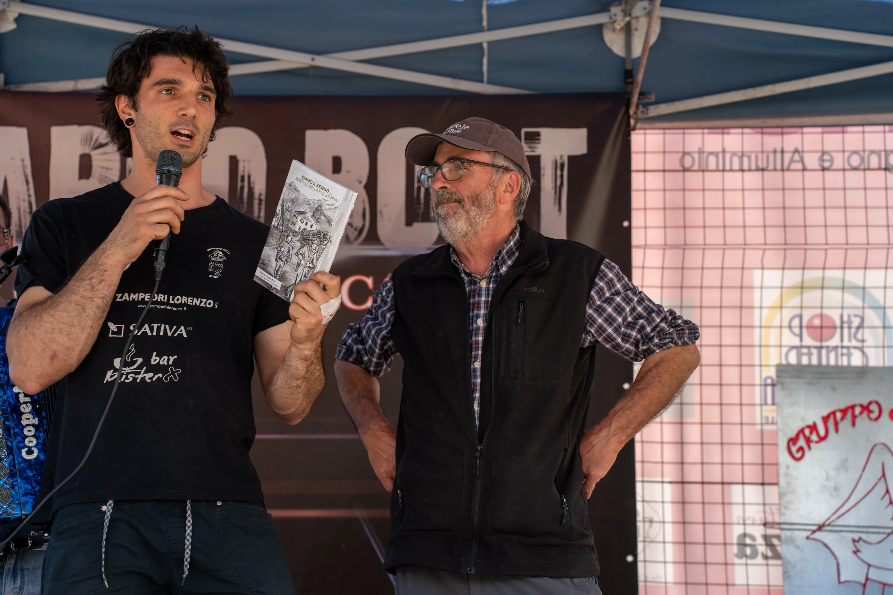 Due uomini al microfono durante la premiazione della marcia