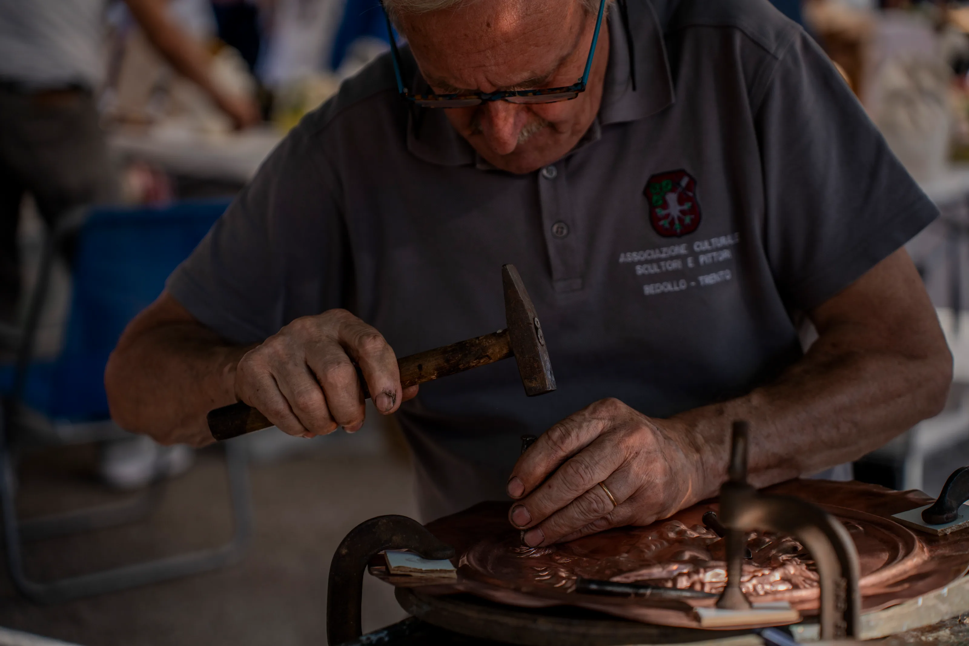 Le mani di uno scultore che lavora il legno con lo scalpello