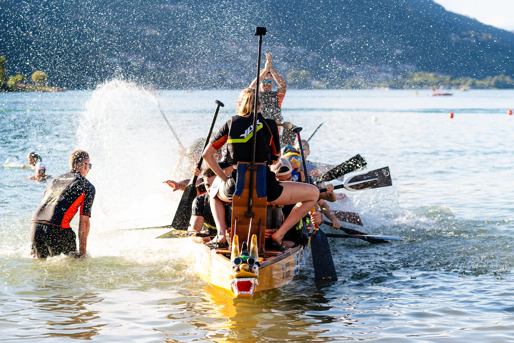 Un equipaggio in acqua fra gli spruzzi, con la prua a testa di drago