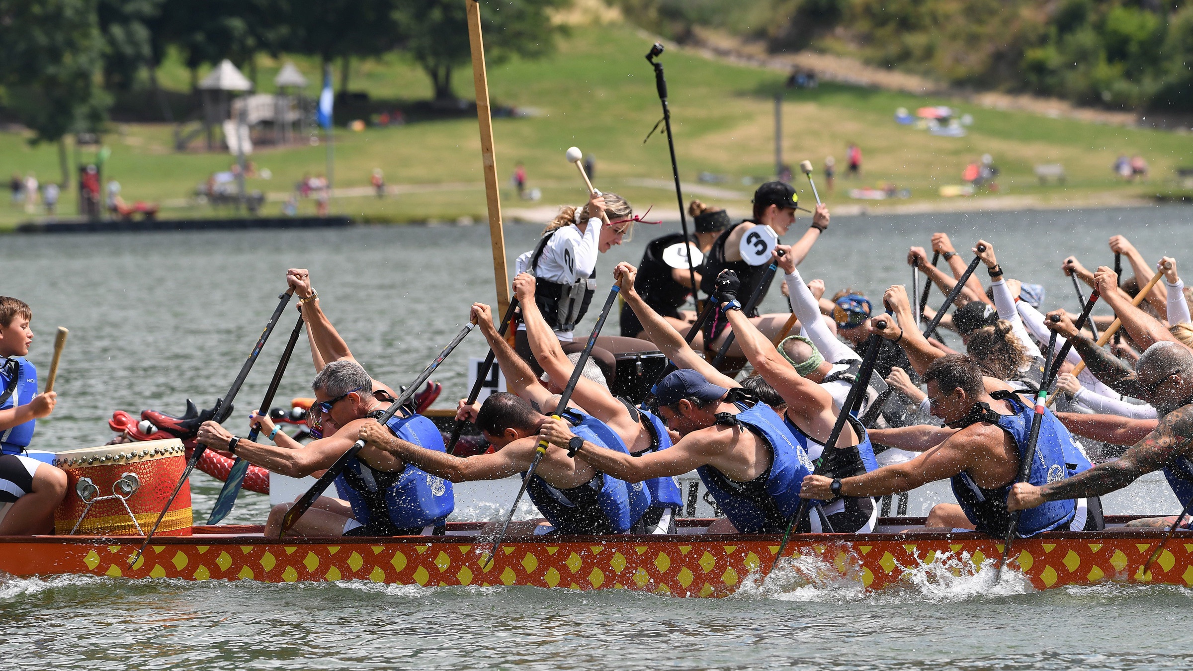 Equipaggio di dragon boat in piena competizione a remi durante il Dragon Festival Piné
