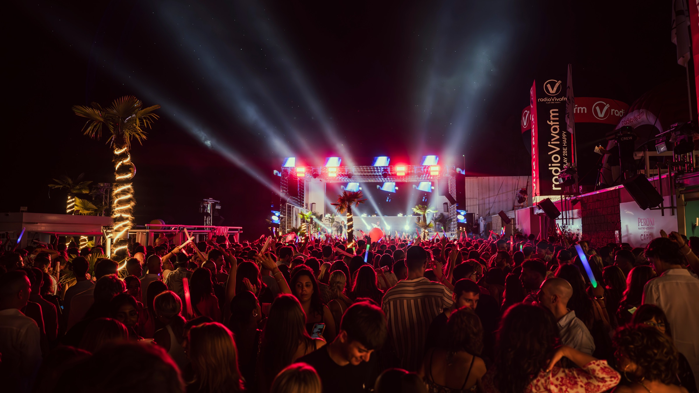 Palco con fasci di luce e folla in festa durante Viva is Back di Radio VivaFm al Coco Beach Club