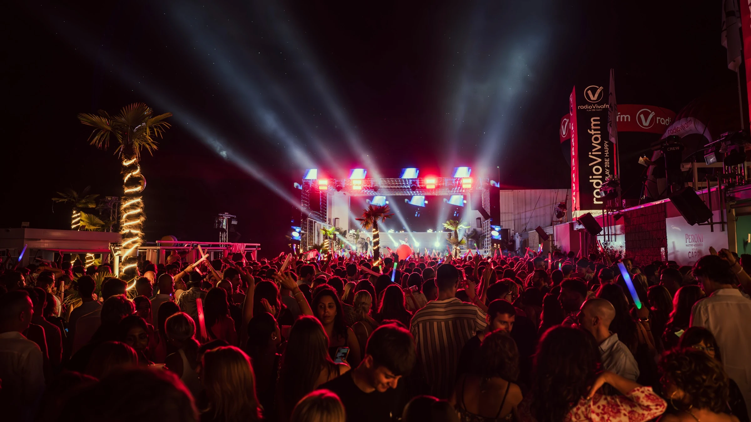 Palco con fasci di luce e folla in festa durante Viva is Back di Radio VivaFm al Coco Beach Club