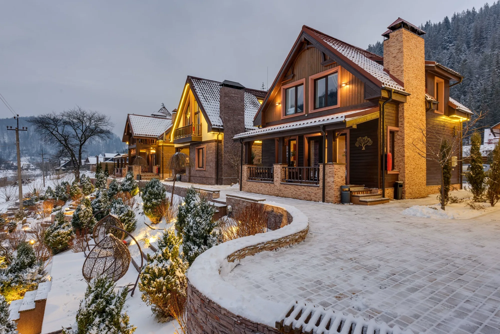 Uno chalet di legno con le luci accese, circondato dalla neve