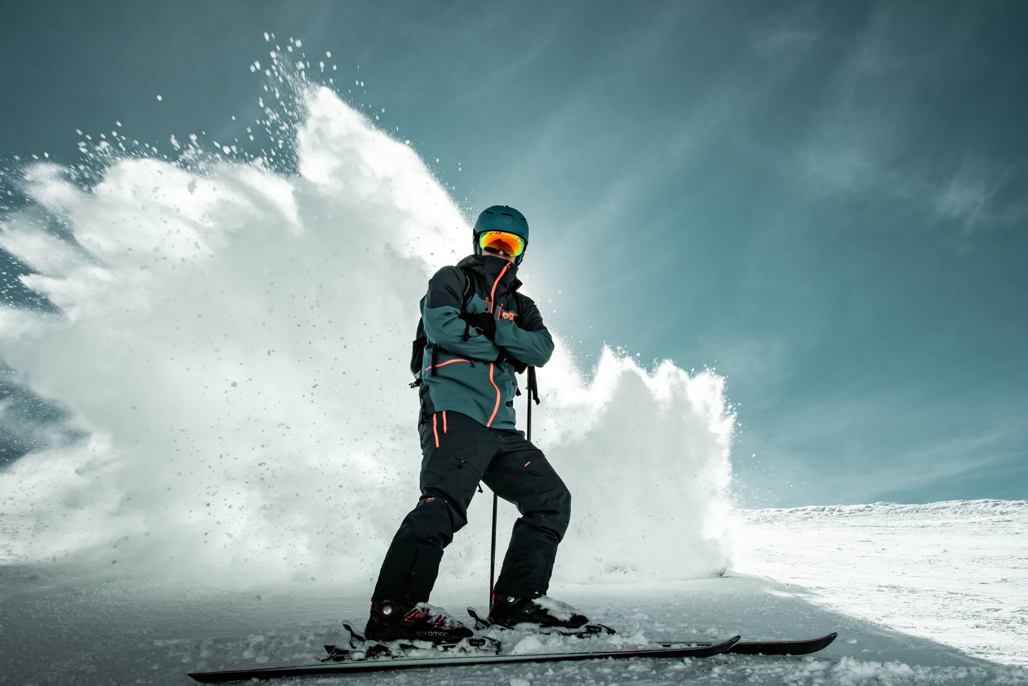 Uno sciatore alza un muro di neve fresca curvando