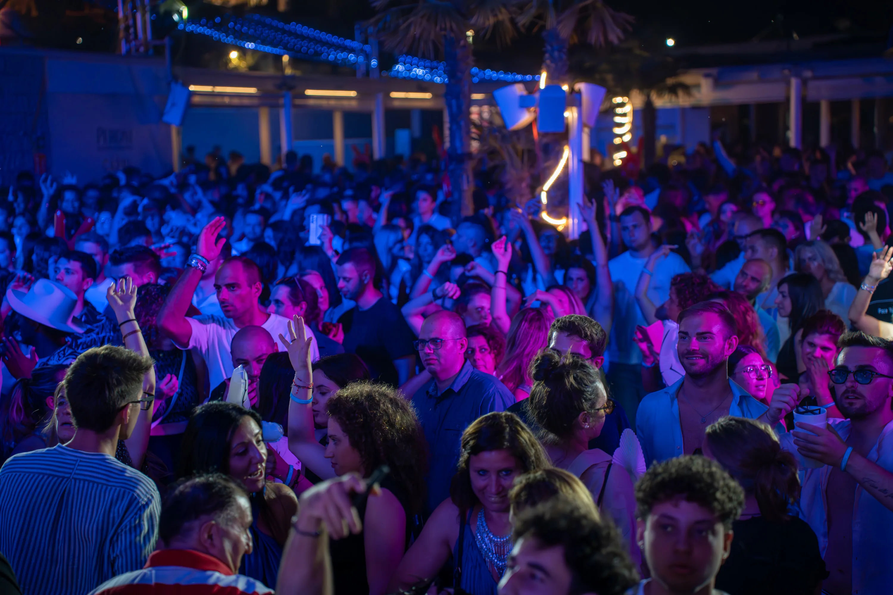 Il pubblico sotto la luce blu, con le braccia alzate