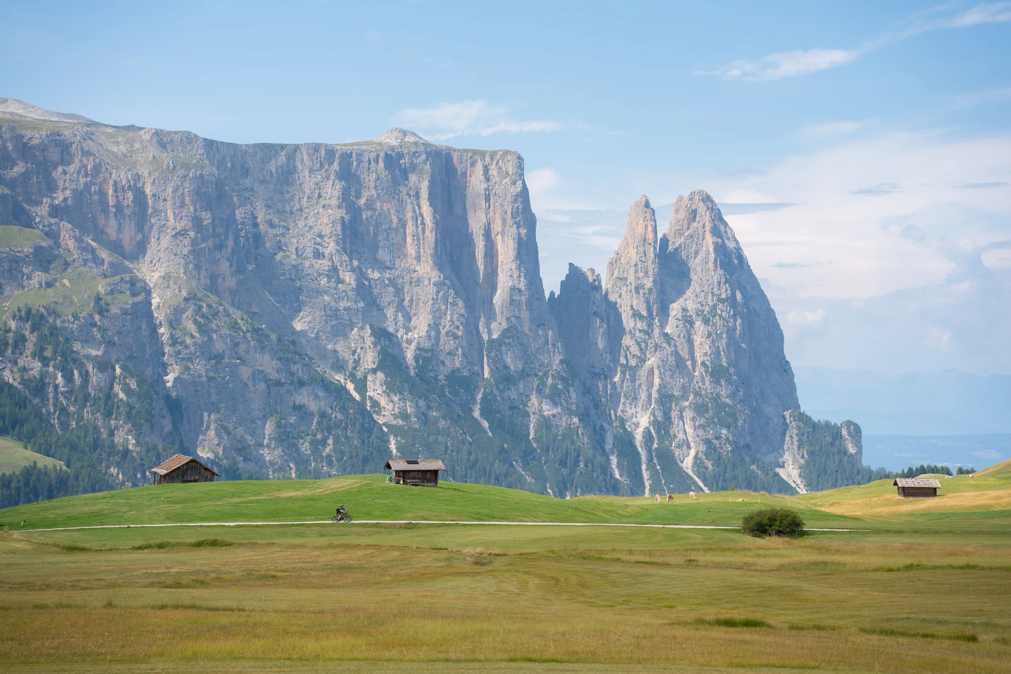 L'Alpe di Siusi con le baite e le cime dolomitiche, sotto il cielo sereno