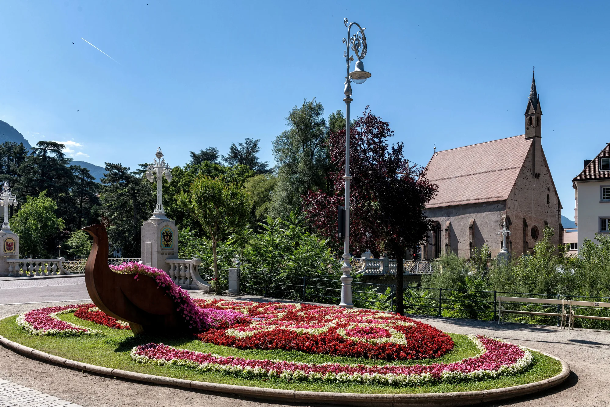 Una chiesa storica di Merano, con il giardino in fiore sotto il sole d'estate