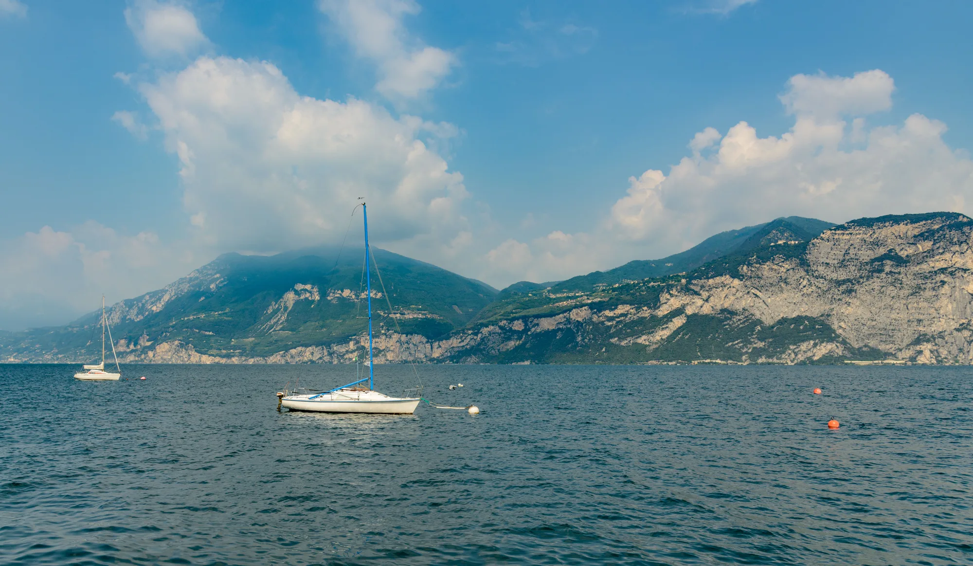Barche a vela sul lago di Garda, con le montagne alle spalle