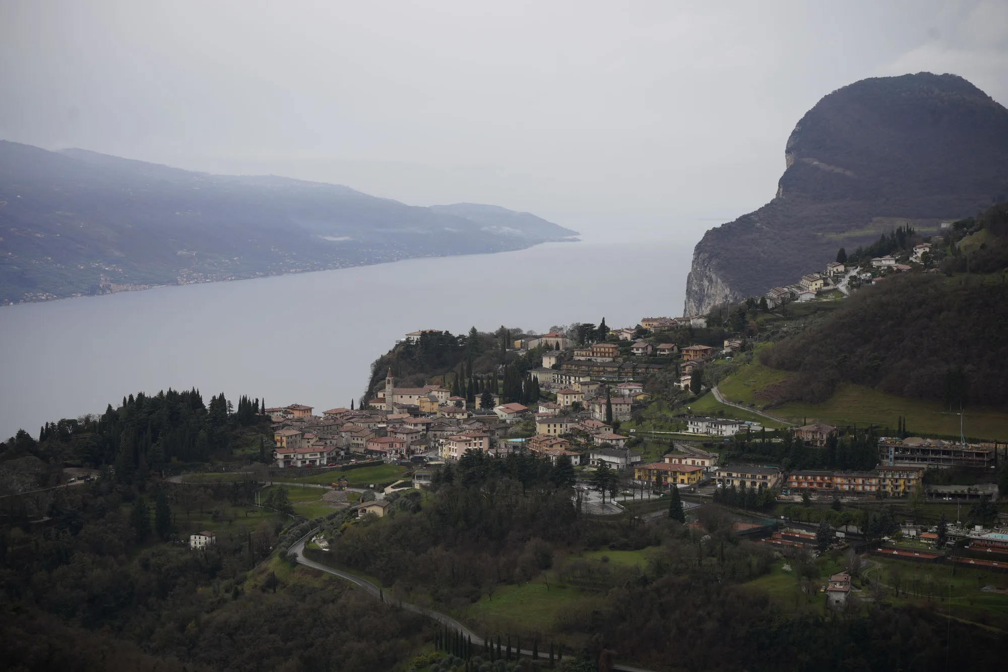 Veduta aerea del lago di Garda con le montagne e un paese