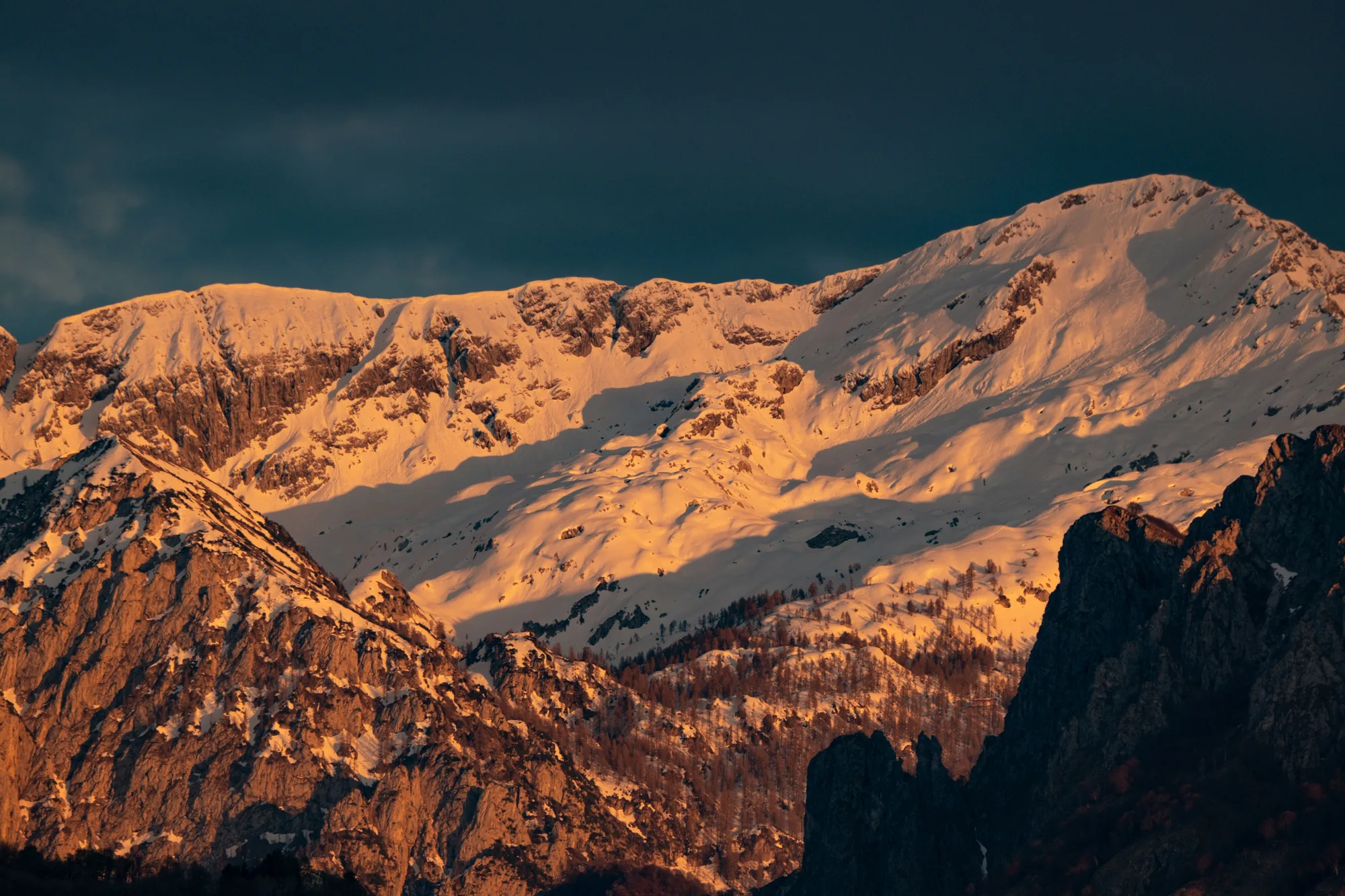 Il tramonto dorato sulle montagne innevate